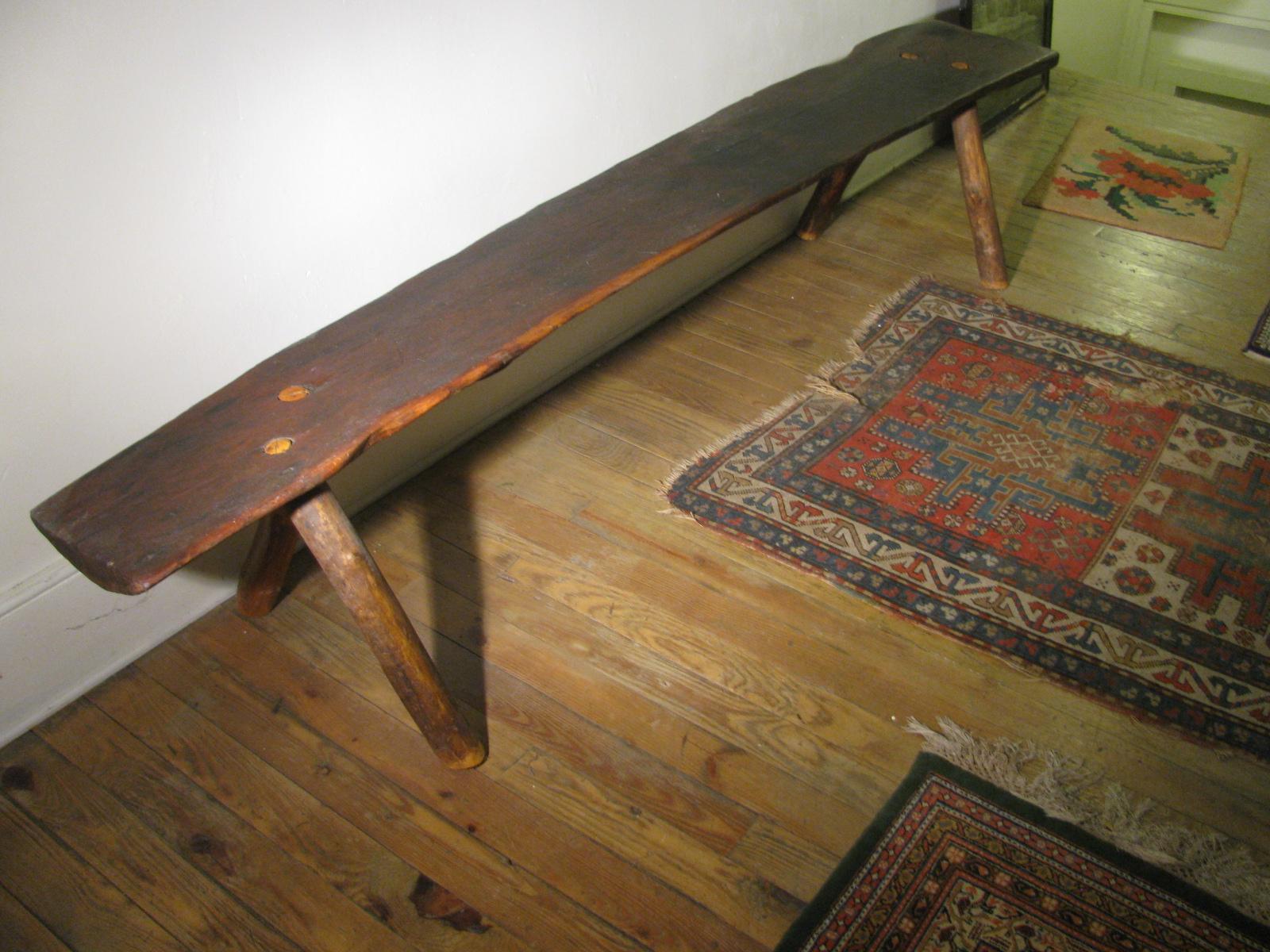 Fabulous eight foot plus black walnut Adirondack bench. Legs were replaced about ten years ago as the originals had rotted away. Legs are mortised thru the top with splines, wedges to lock them in place. Slight curve downward on one end of the bench