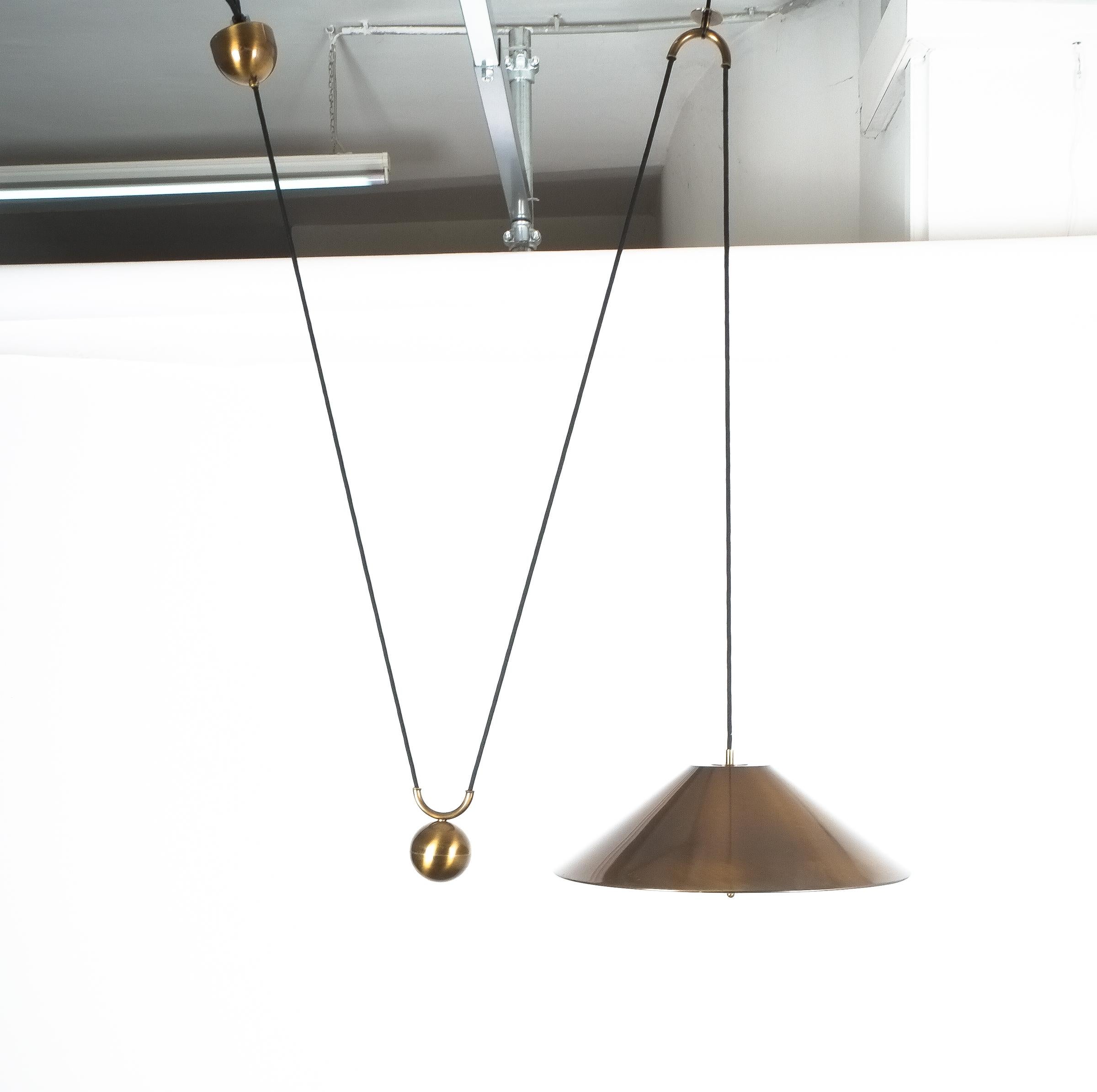 Large adjustable brass counterweight pendant lamp by Florian Schulz. Elegant burnished brass counterbalance light by Florian Schulz/Germany with a 20 inch shade and heavy counterweight to easily adjust the light in height. Very good condition, it