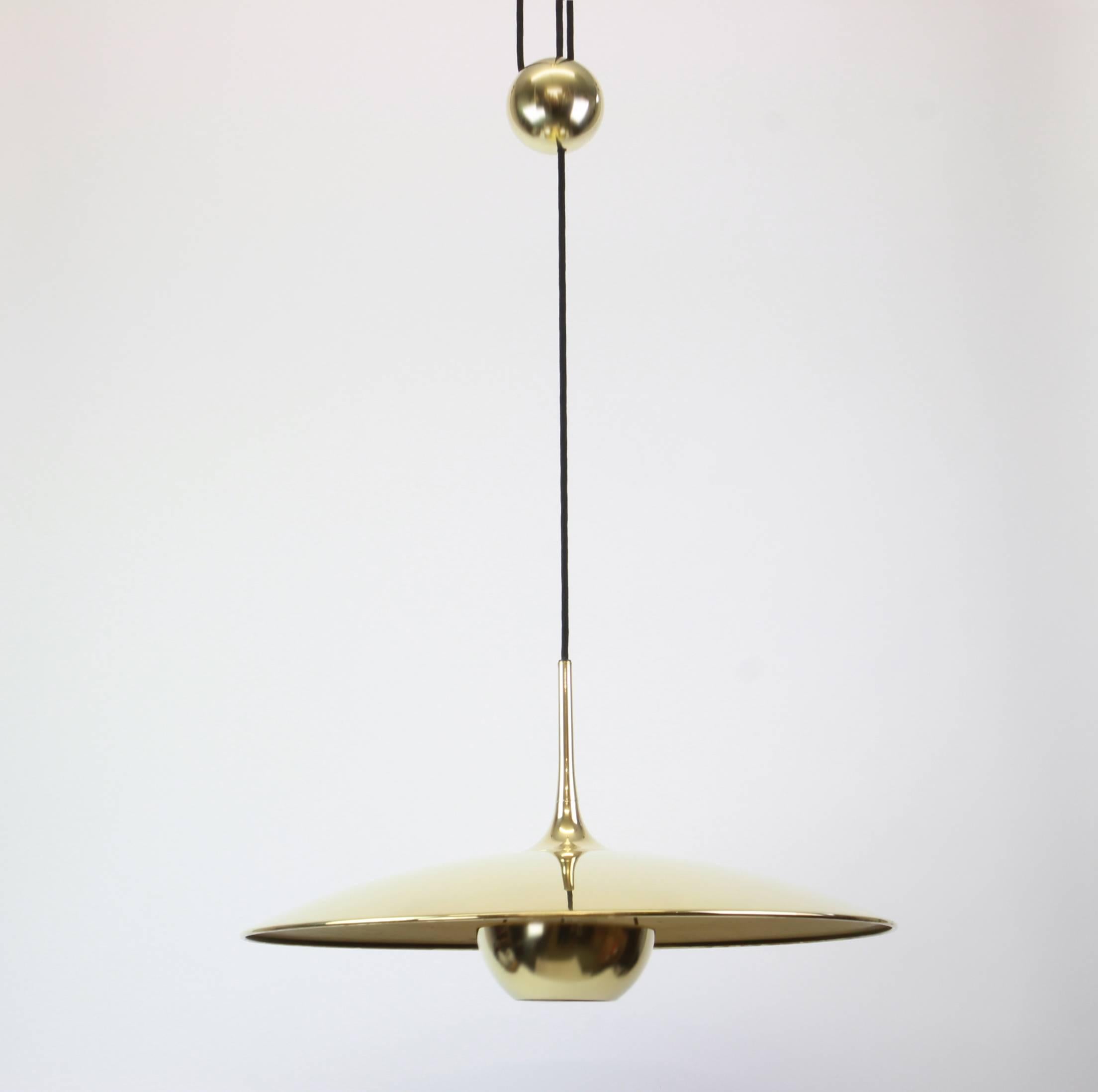 Brass counter balance pendant by German lighting designed by Florian Schulz. Heavy brass ball counter-weight and brass disc. Cloth cord. 

 Excellent vintage condition. Height is adjustable.

Sockets: 1 x E26/E27 standard bulb 

Dimensions: