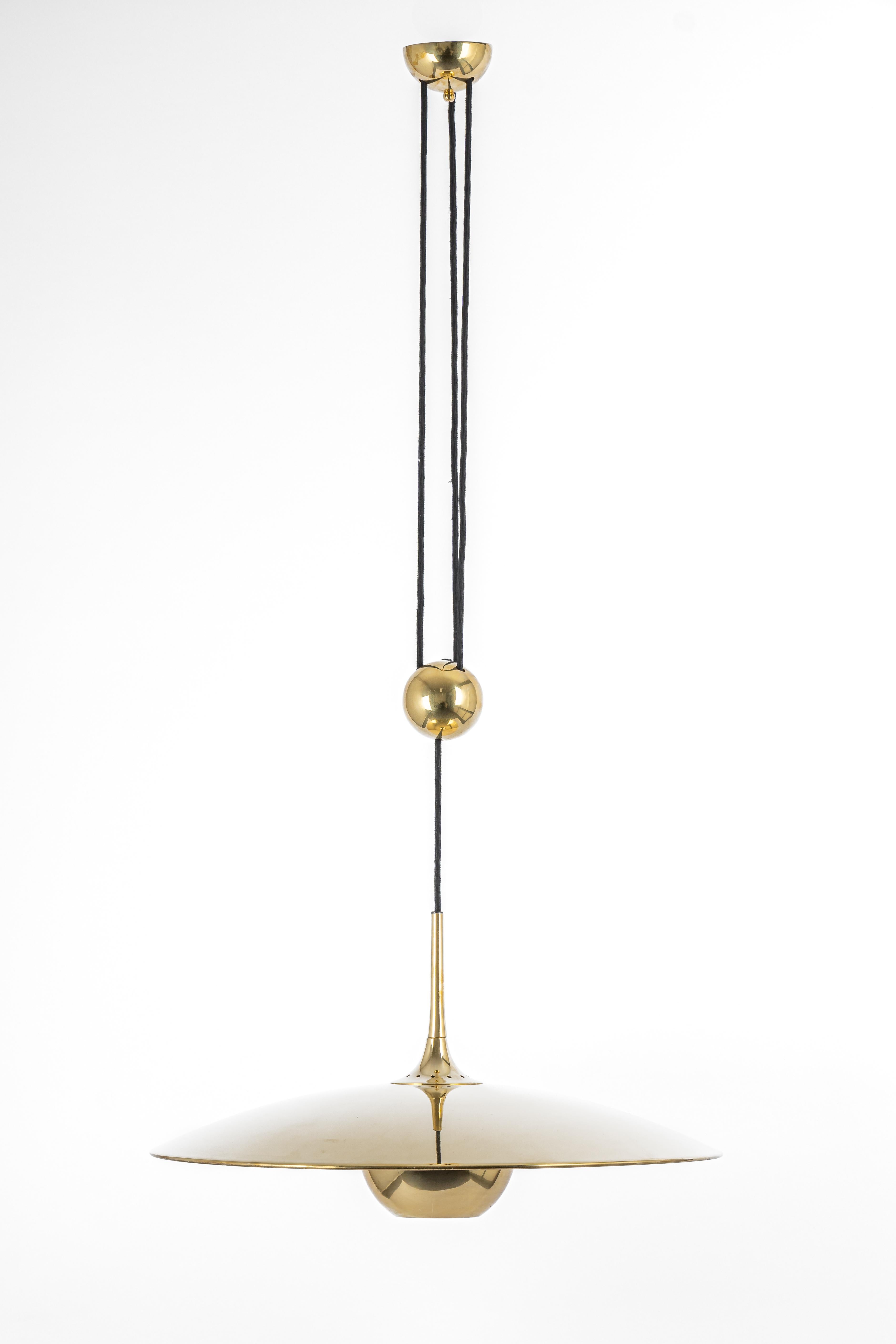 Brass counter balance pendant by German lighting designed by Florian Schulz. Heavy brass ball counterweight and brass disc. Cloth cord. 

 Very good vintage condition. The height is adjustable.

Sockets: 1 x E26/E27 standard bulb 

Dimensions: