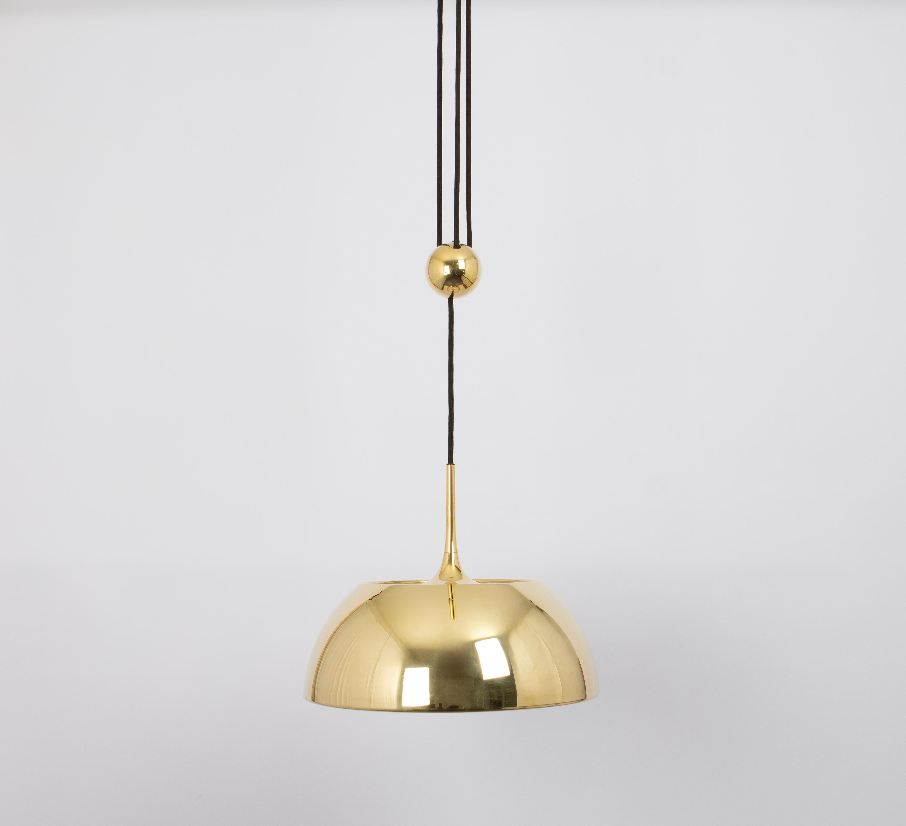 Large adjustable brass counterweight pendant light designed by Florian Schulz, Germany, 1970s.
It is a masterpiece of design and craftsmanship. It seamlessly blends functionality and aesthetics to create a lighting fixture that's as much an art