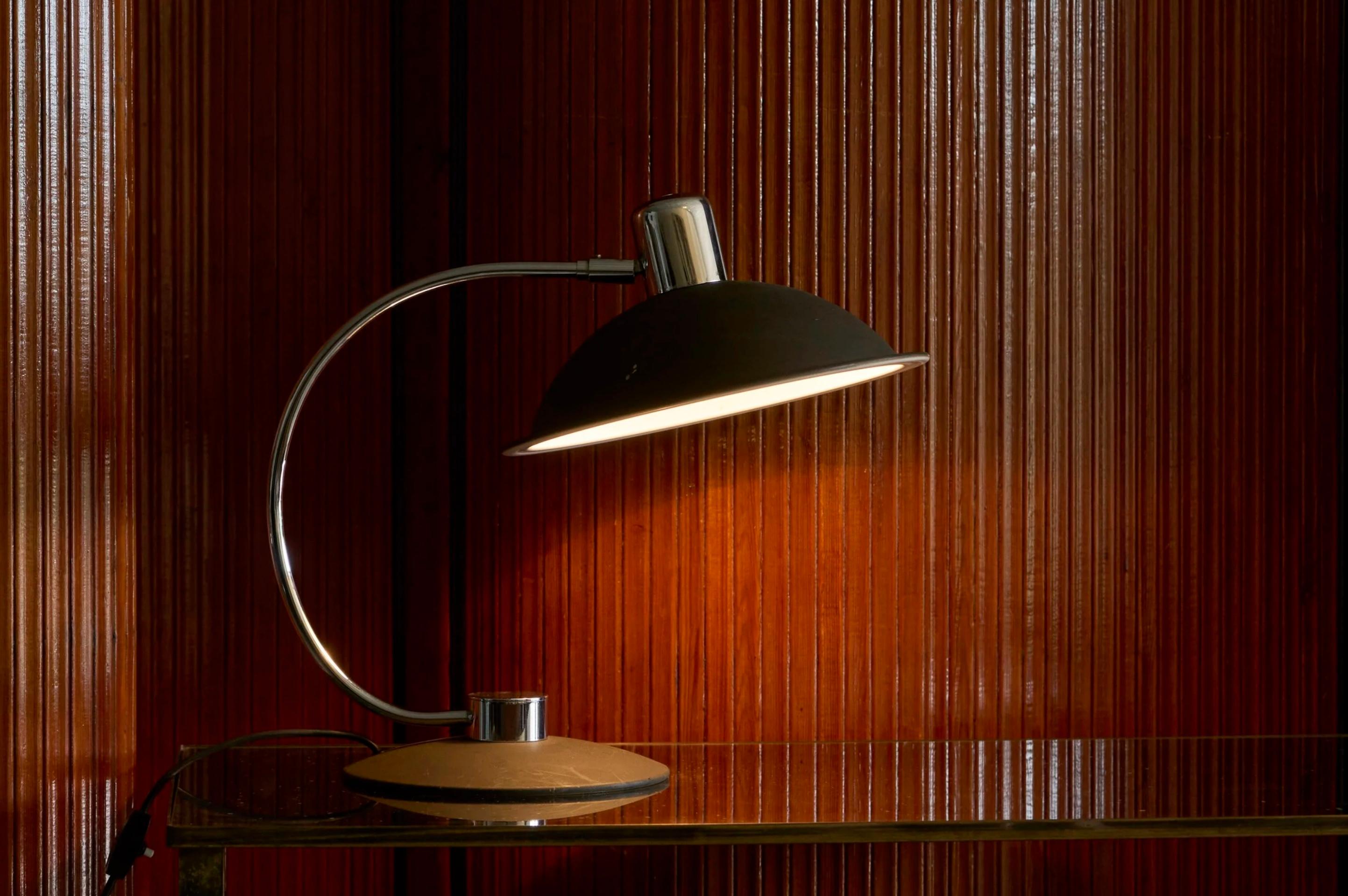 Large Adjustable Mid Century Table Lamp in Chrome and Black

A very distinct mid century modernist table or desk lamp in chrome and black painted metal. 

Great design with a hat shaped shade, a nicely curved stem and a round base. High quality