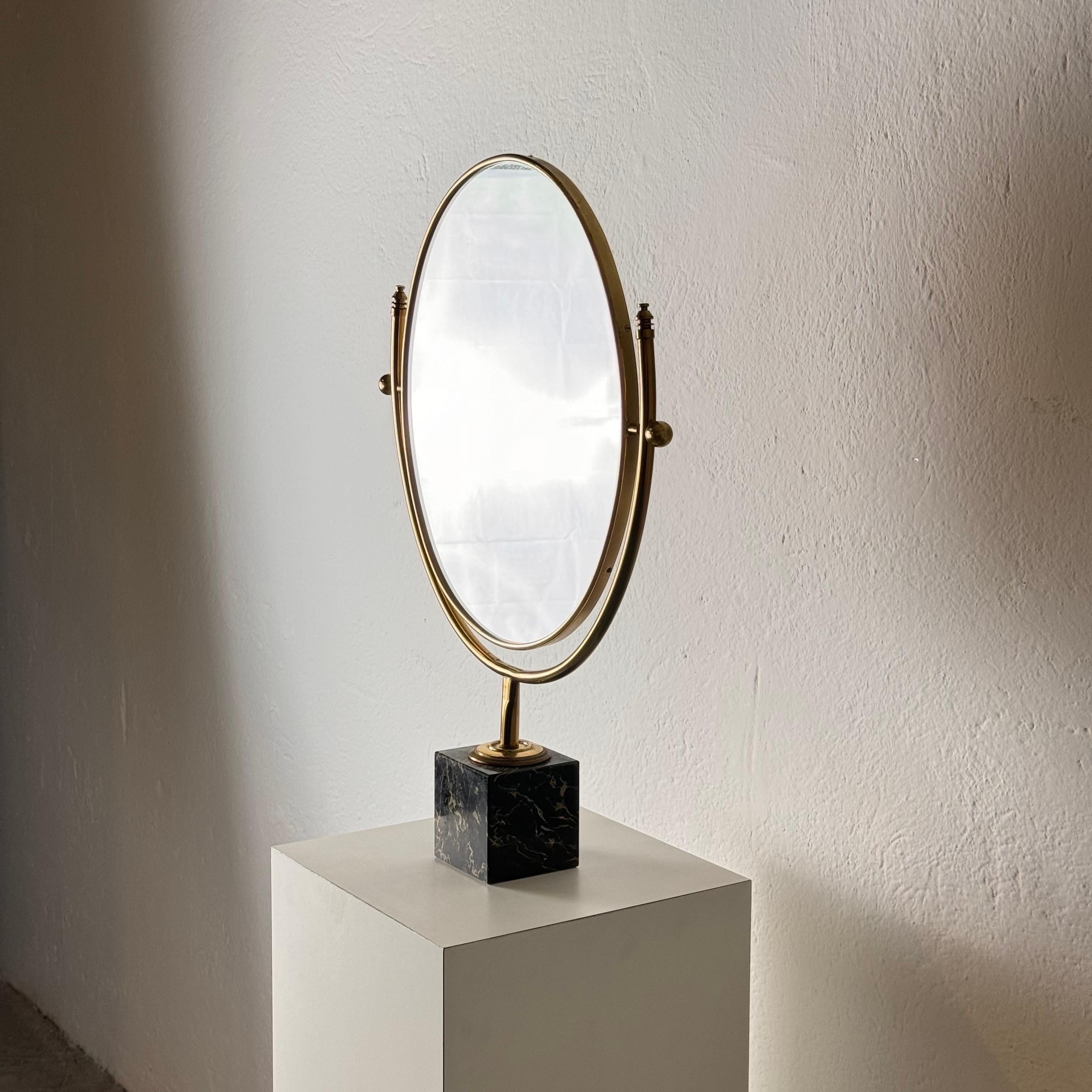 Questo lussuoso specchio da toilette inclinabile degli anni '60 combina eleganza e funzionalità, rendendolo un'aggiunta di spicco a qualsiasi interno raffinato. Realizzato con una splendida struttura in ottone invecchiato e una squisita base in