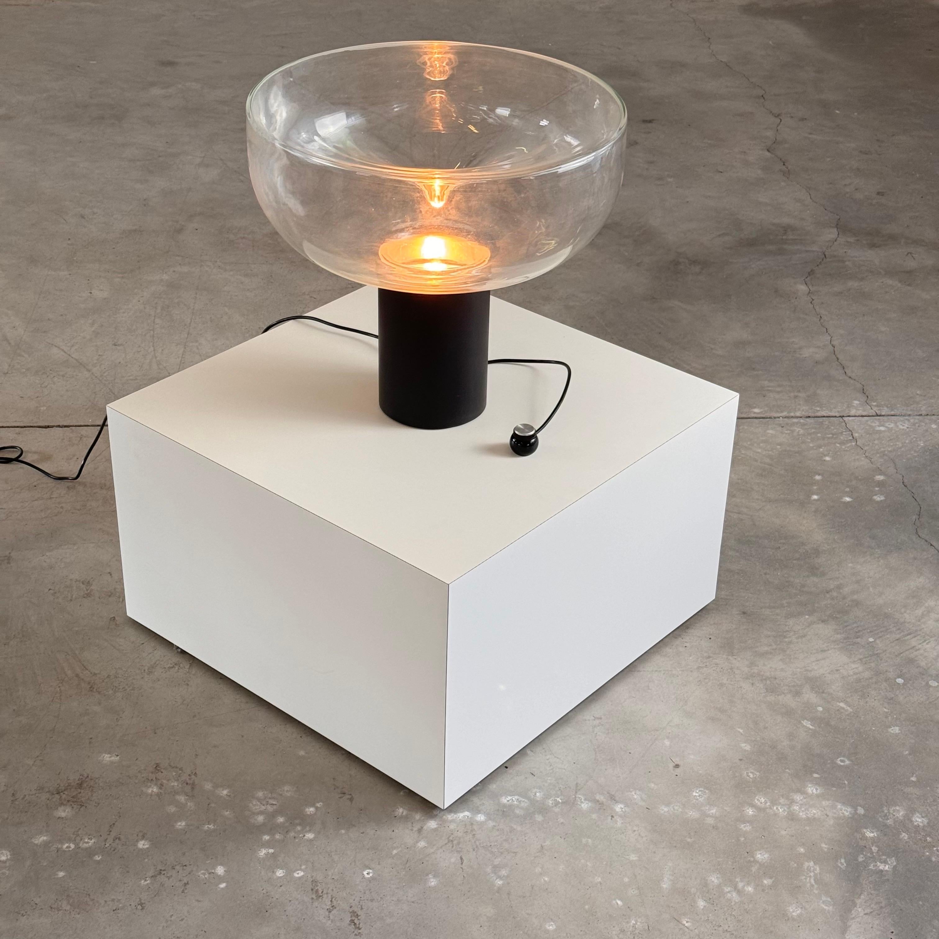 Introducing the captivating Aella 50 table lamp, designed by Renato Toso and Giovanna Noti Massari in 1966 for Leucos. This remarkable piece, named after the mythological Amazon warrior Aella, embodies both an essential and sophisticated