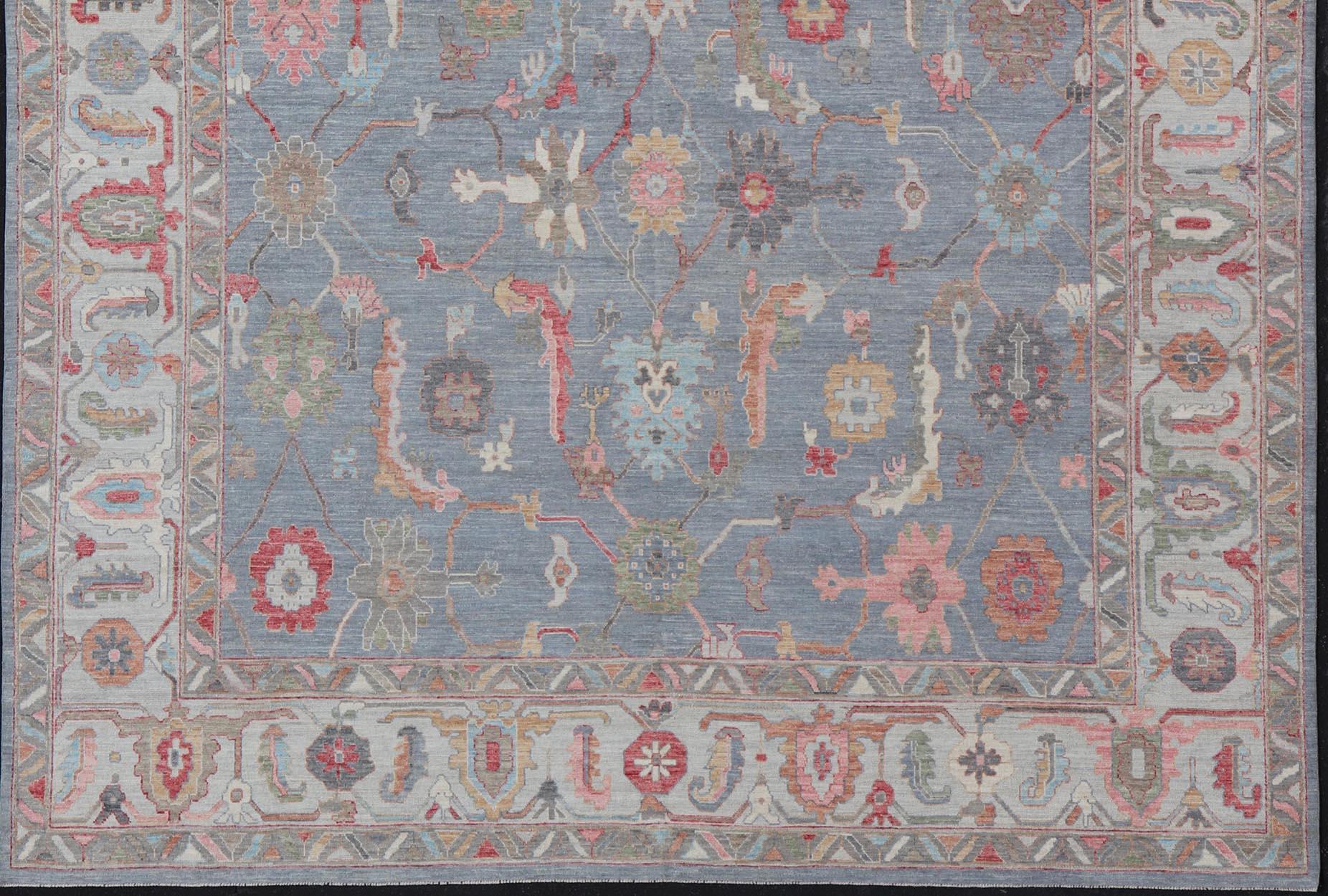 This piece has very rich colors, from the enhanced dark gray-blue background, to the saturated pinks, green, blues, oranges and taupe used in the design, The slightly-arabesque floral pattern also has hints of tribal designs within the field as well