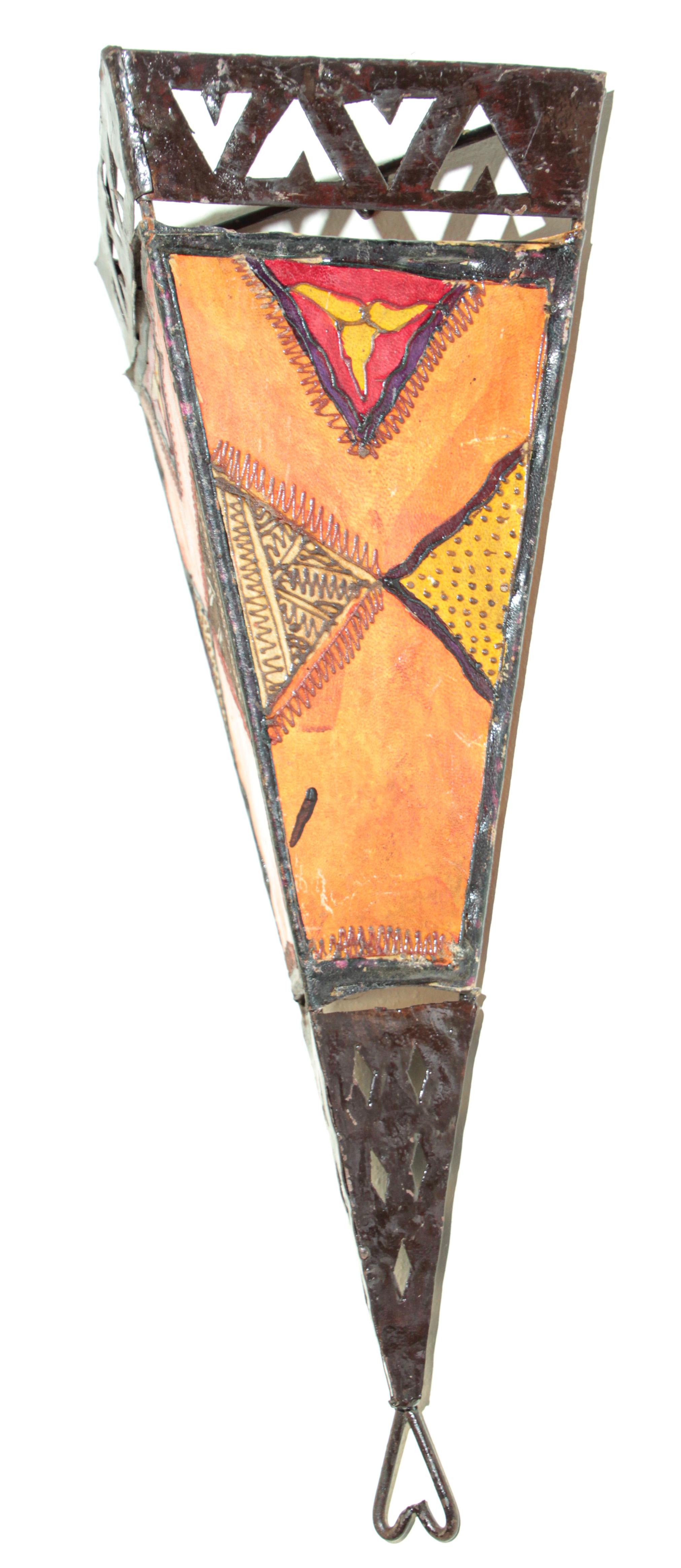 Large African Tribal Art parchment wall shade sconce featuring a large triangle hide form stitched on iron and hand painted surface. 
These Art pieces could be used as wall lamp shade. 
Iron frame with metal open work design covered with hide