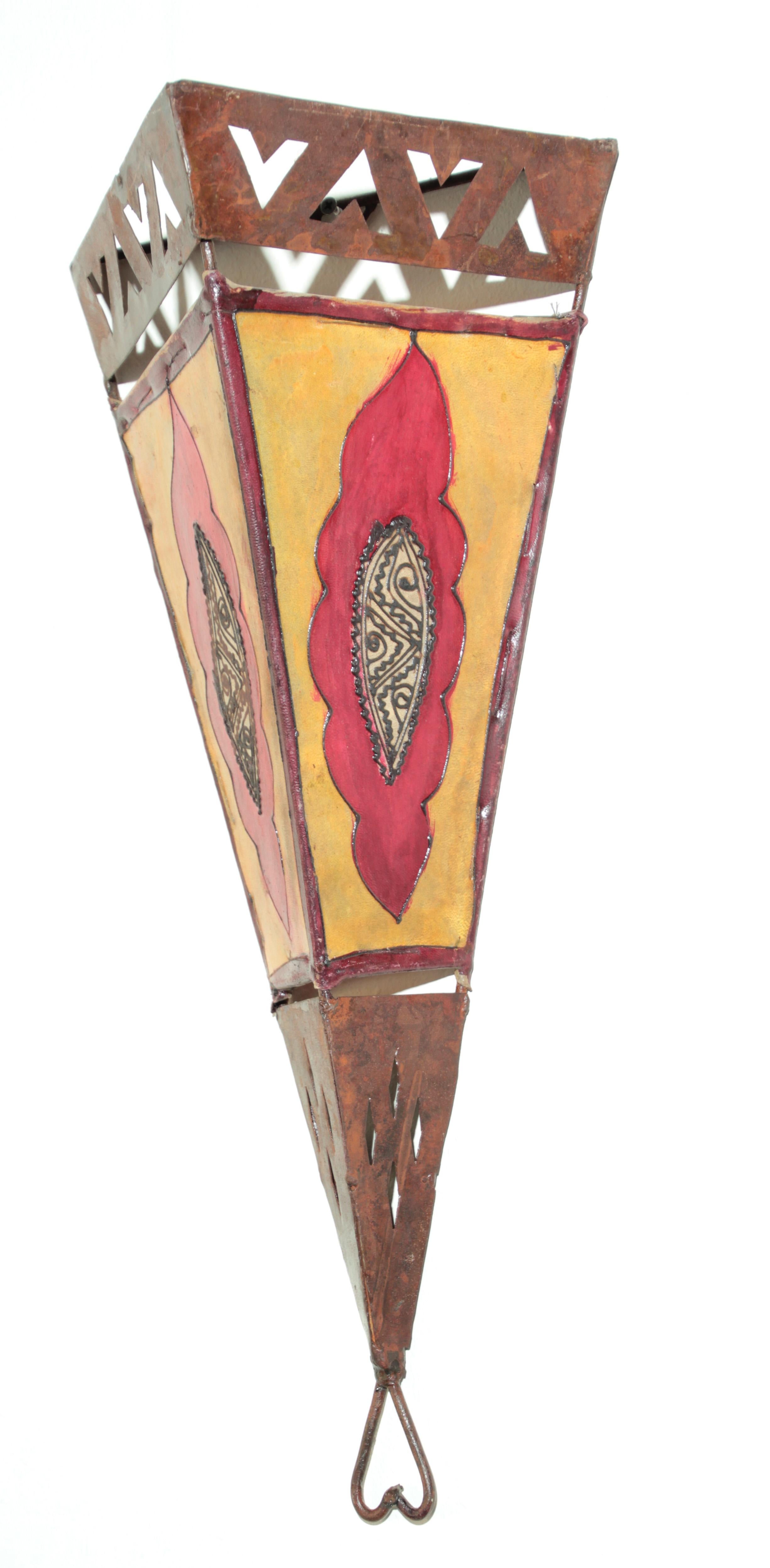 Large African Tribal Art parchment wall shade sconce featuring a large triangle hide form stitched on iron and hand painted surface.
These vintage hand crafted Folk Art pieces could be used as wall lamp shade or just decorative wall Art.
Iron frame