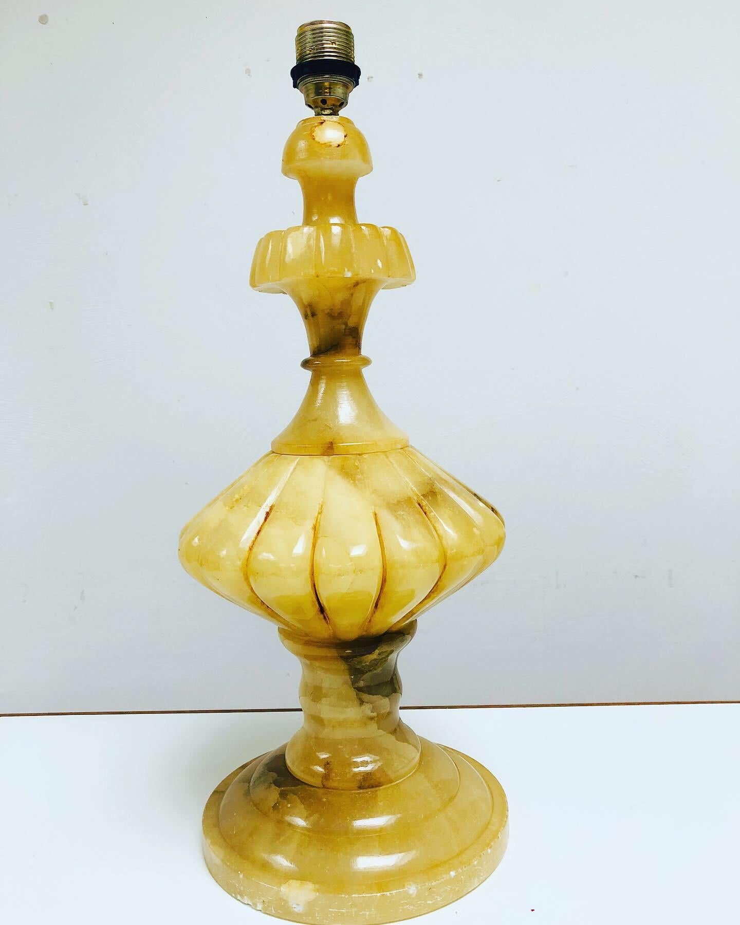 Stylish table lamp made of alabaster in Baroque style. The alabaster has a natural and warm yellowish colour with light brown veins. 