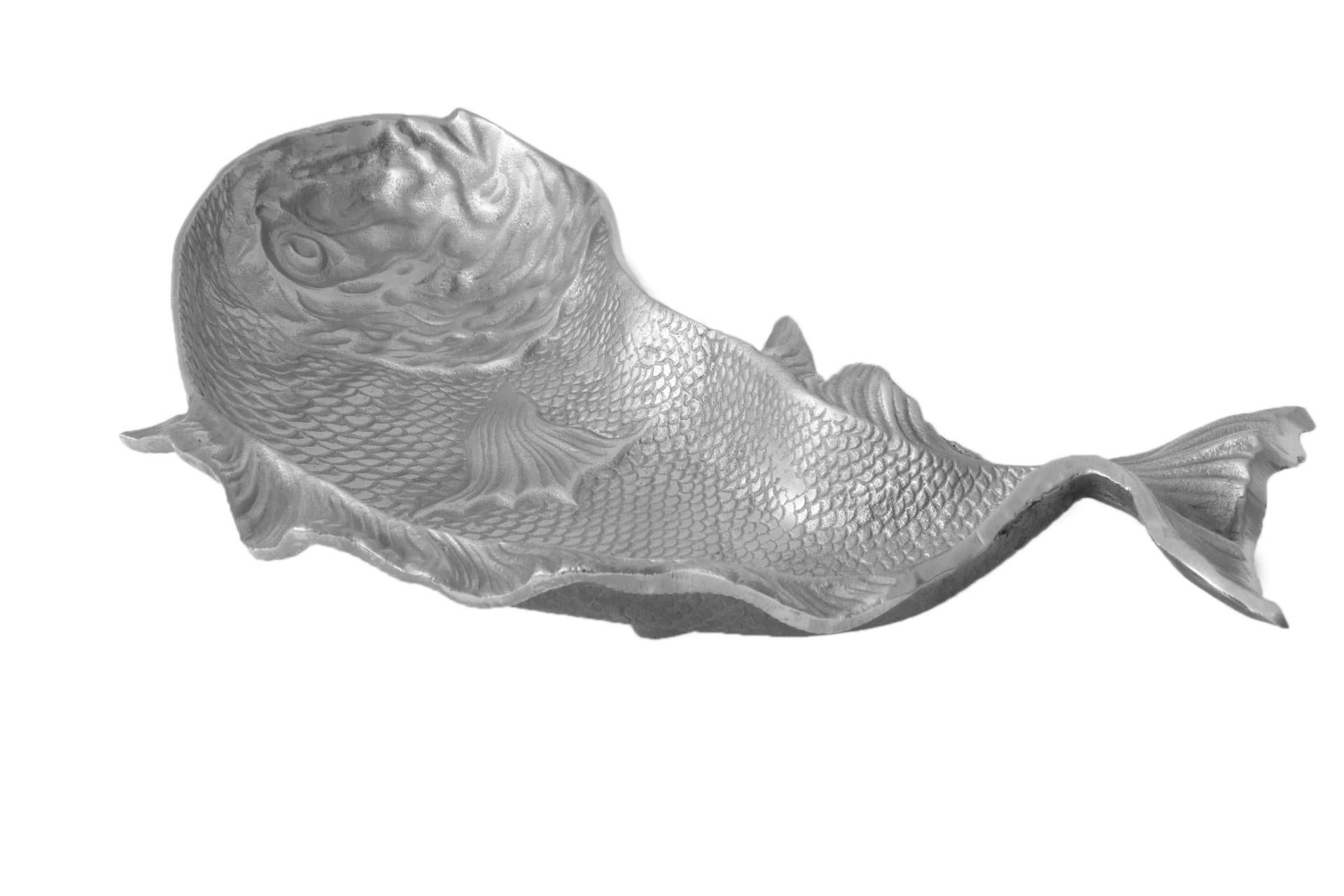 A heavy aluminum platter pressed in the shape of a fish. The eye and mouth are clearly defined and the platter is covered throughout with fine scales. Flowing fins twist at the rim adding movement.