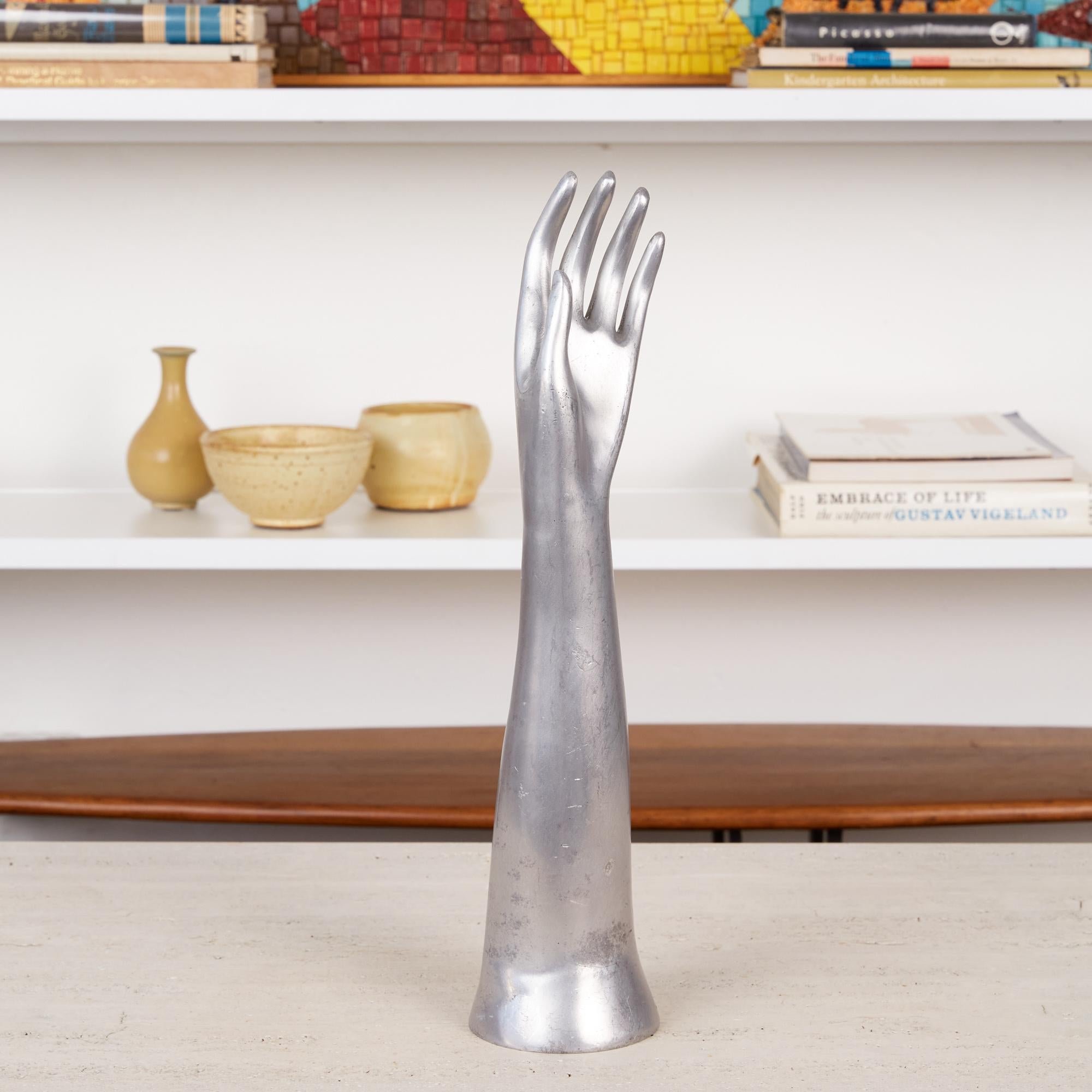 Heavy in weight, but graceful in form, this cast aluminum left forearm features a delicate hand at its crest. Its feminine, graceful fingers carry a sense of longing, reaching out for the ethereal. Can be used as bookcase or table decor or to