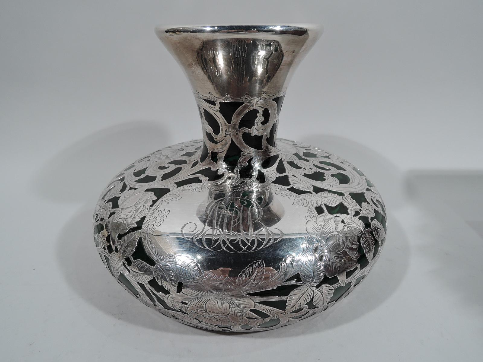 Large turn-of-the-century Art Nouveau glass vase with engraved silver overlay. Round and bellied with short and conical mouth and neck. Floral overlay with ripe blooms amidst dense leaves and scrolls. Scrolled cartouche engraved with interlaced