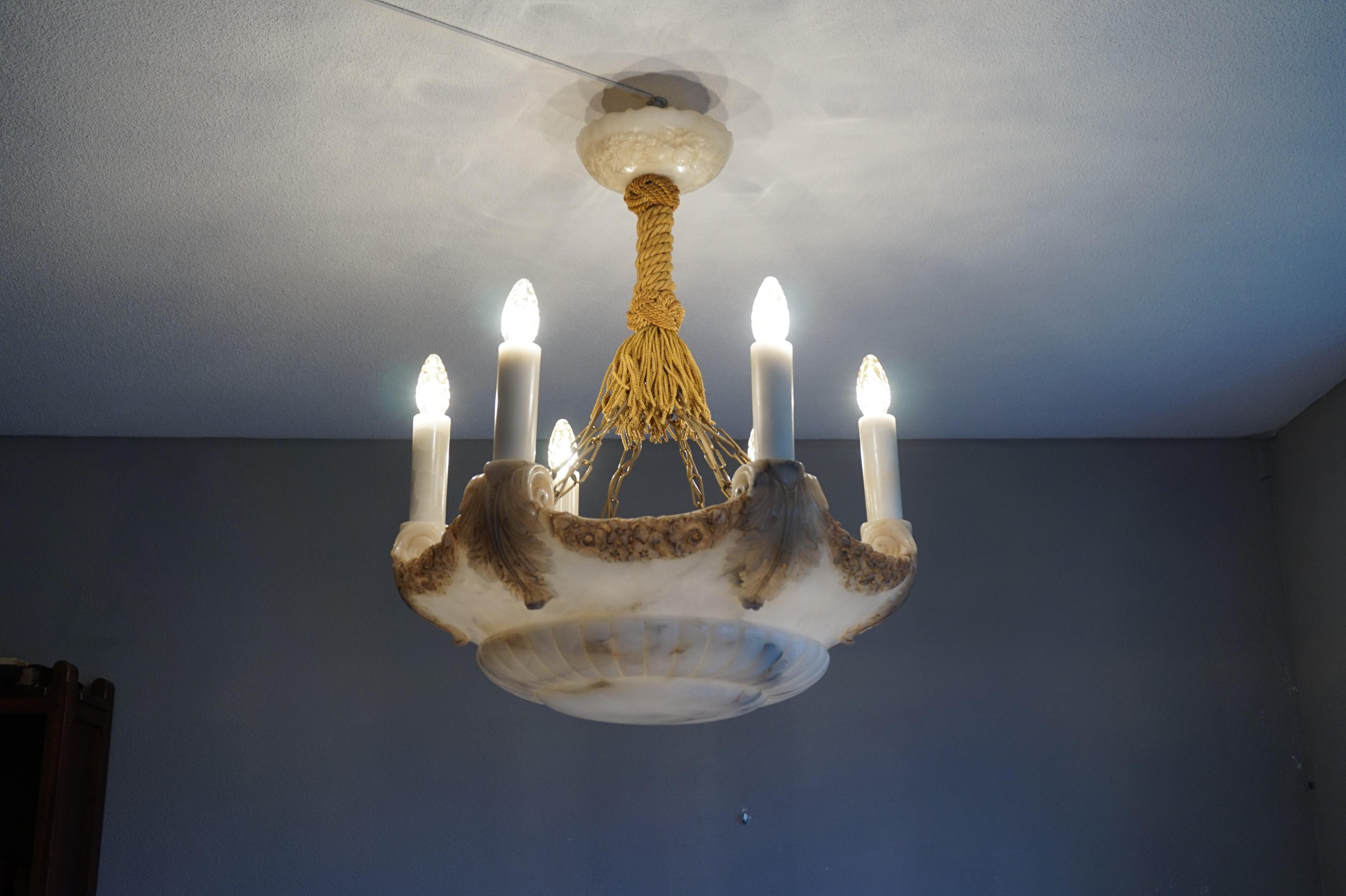 Monumental antique alabaster chandelier with amazing carvings.

With early 20th century lighting as one of our specialties we are certain that this Classical Revival alabaster chandelier was one of the first alabaster chandeliers that was created.