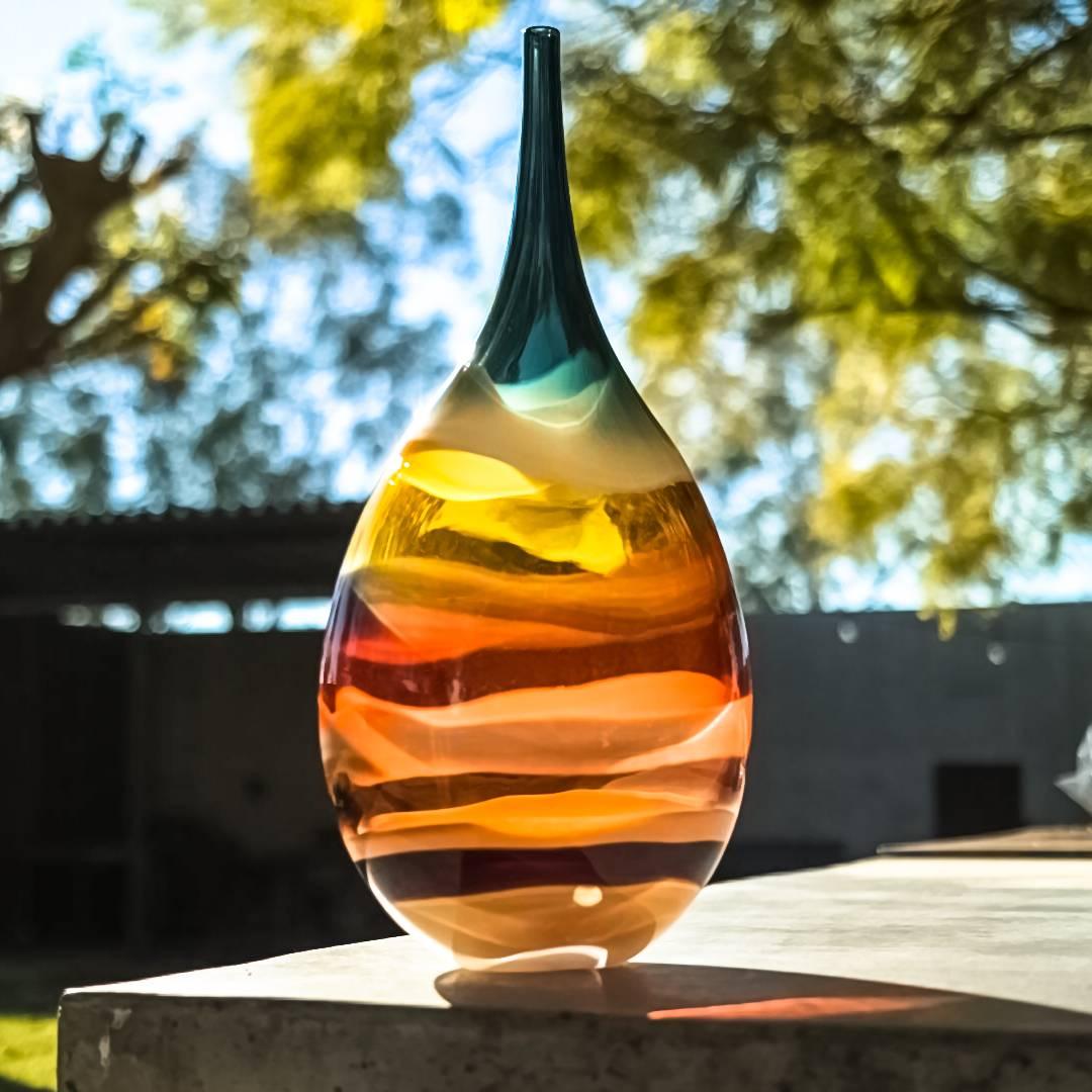 These striking pieces draw inspiration from the rich hues and undulating topography of Southern California. Alternating layers of opaque and transparent colors are applied to clear glass to create a Scandinavian Modern style. Overlaps create