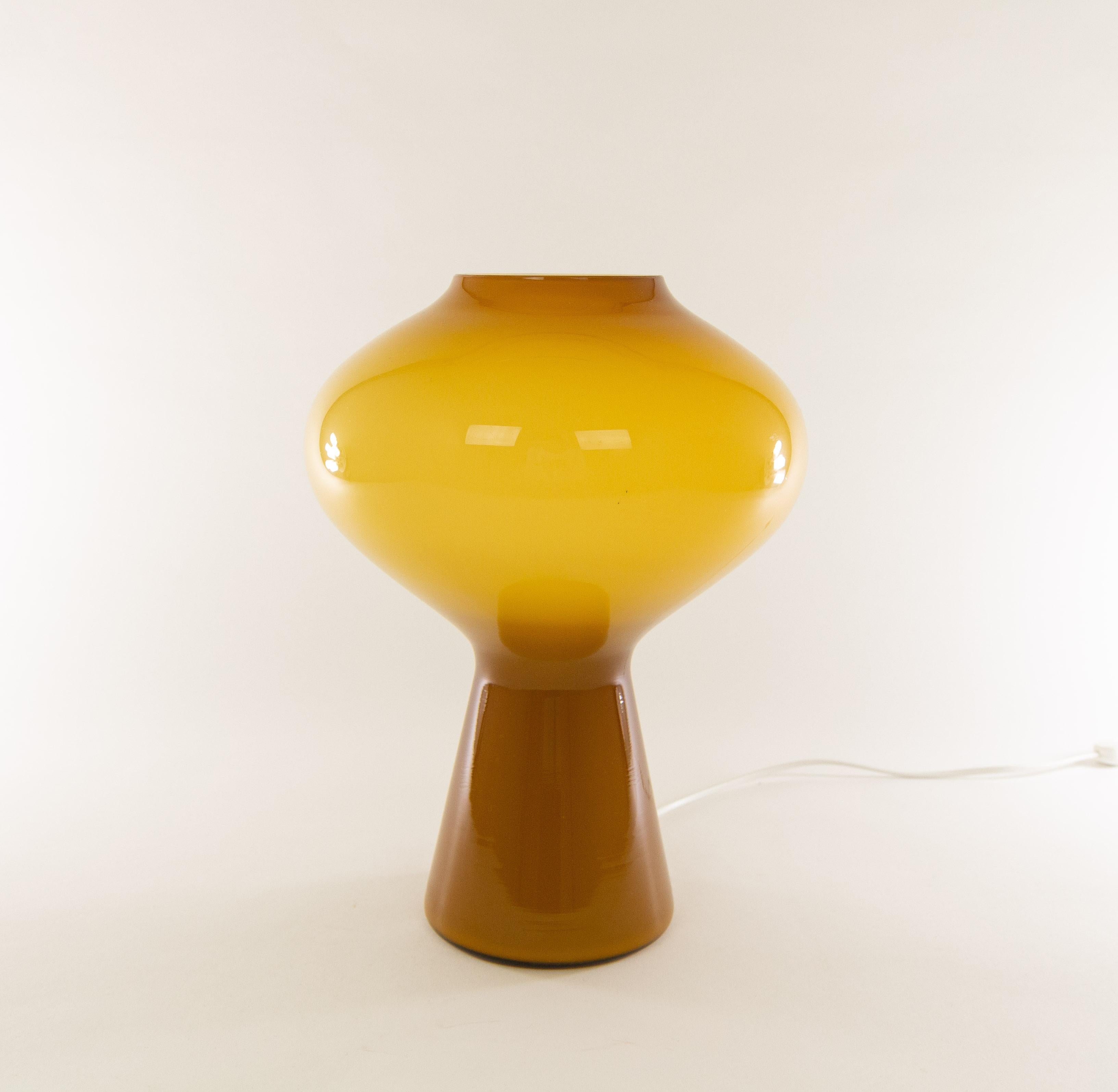 A hand blown amber colored glass Fungo table lamp designed by Massimo Vignelli at the start of his impressive career in design and executed by Murano glass specialist Venini. 

This is the largest size of the Fungo table lamp (for the difference