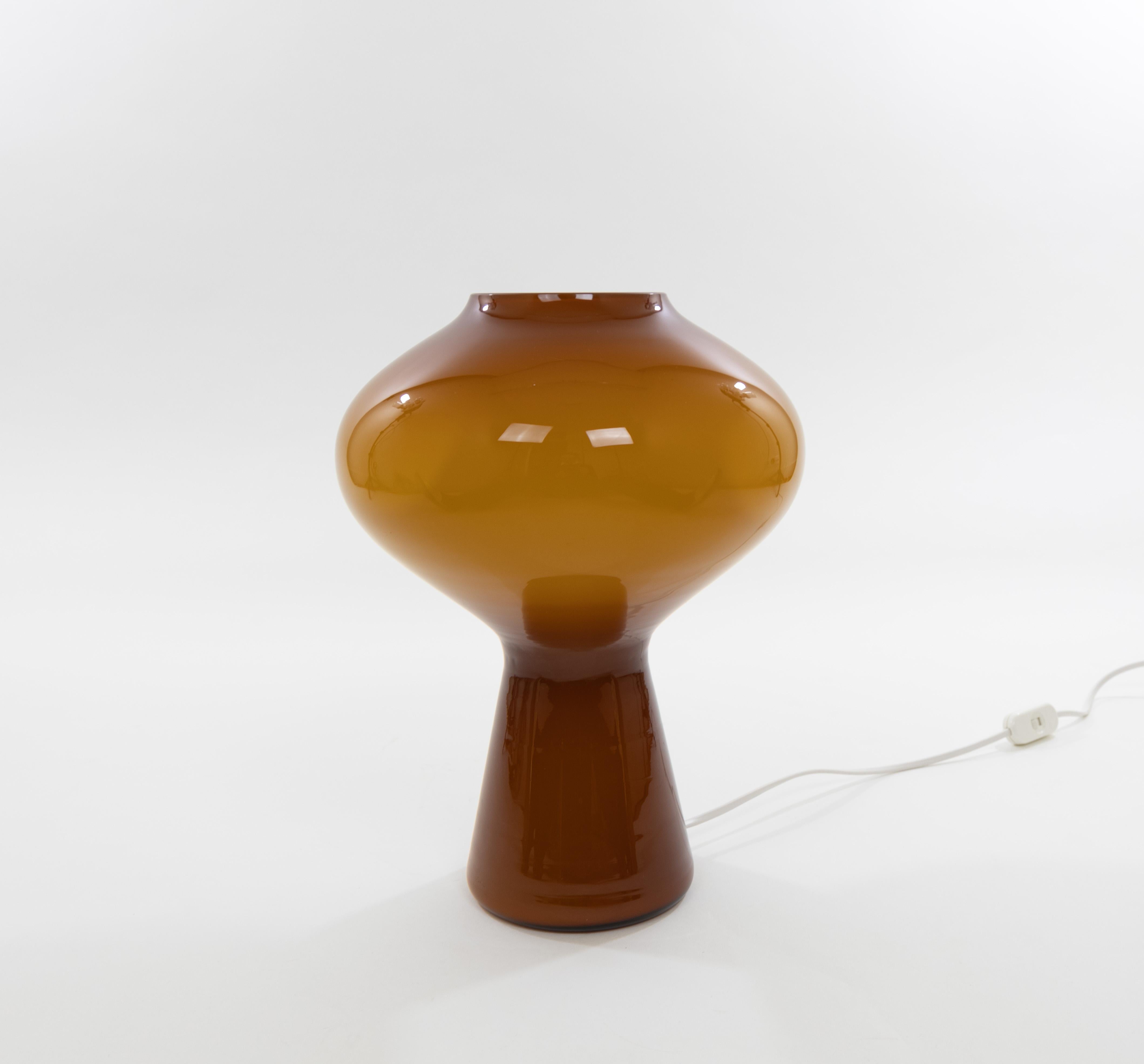 A hand blown amber colored glass Fungo table lamp designed by Massimo Vignelli at the start of his impressive career in design and executed by Murano glass specialist Venini. This is the largest size of the Fungo table lamp.

The Fungo lamp is