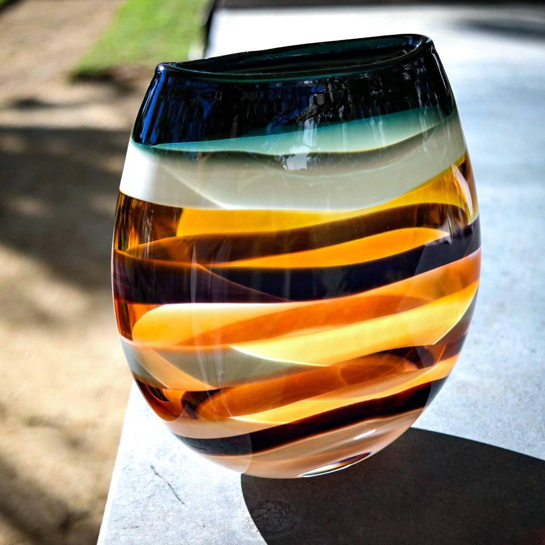 Signed Piece.
These striking pieces draw inspiration from the rich hues and undulating topography of Southern California. Alternating layers of opaque and transparent colors are applied to clear glass. Overlaps create opportunities for new colors to