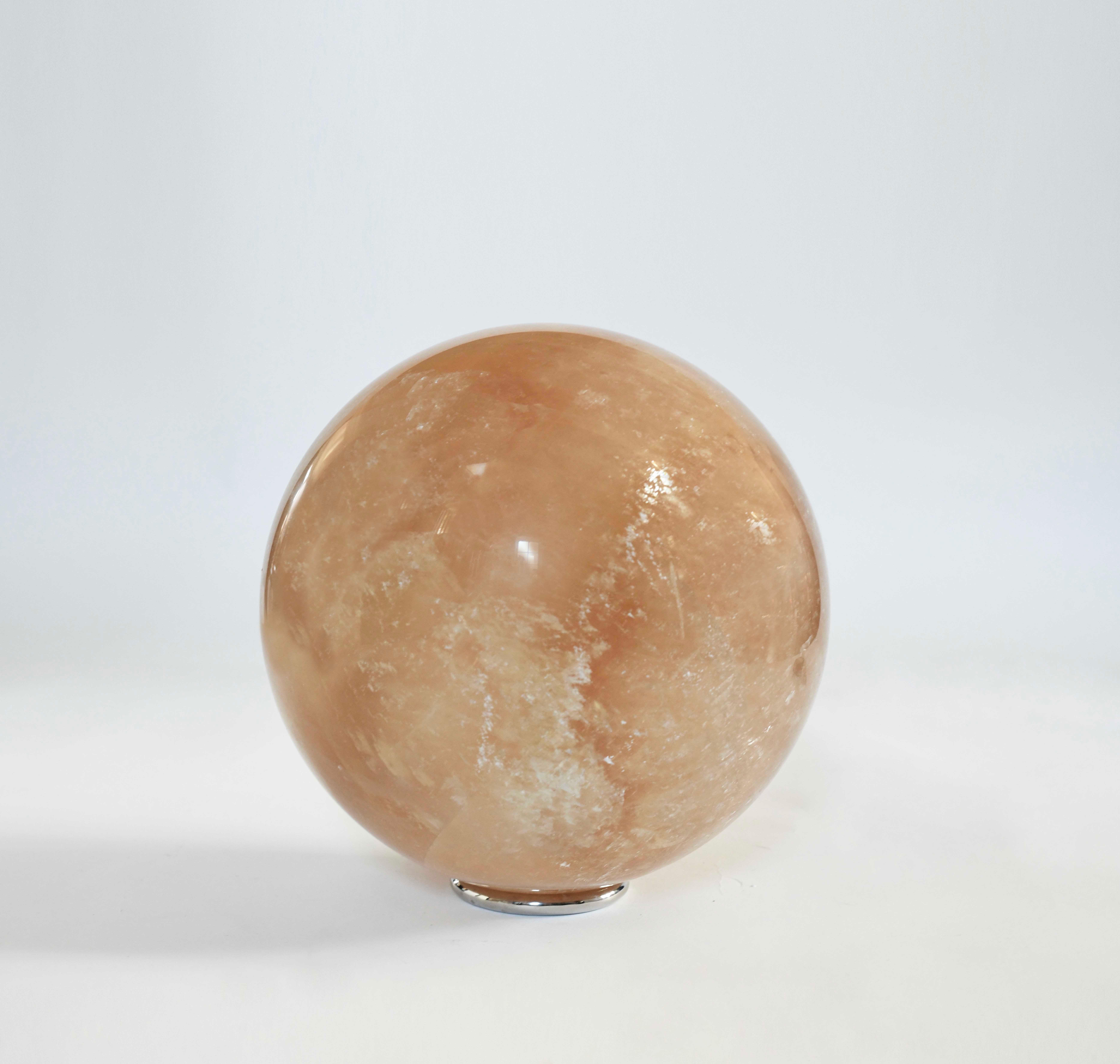 Large semi-translucent amber rock crystal quartz ball with polish nickel base.
From the Oligocene (circa 30 million years ago), of a natural amber Quartz ball with semi-transparent mineralized veins of beautiful movement.