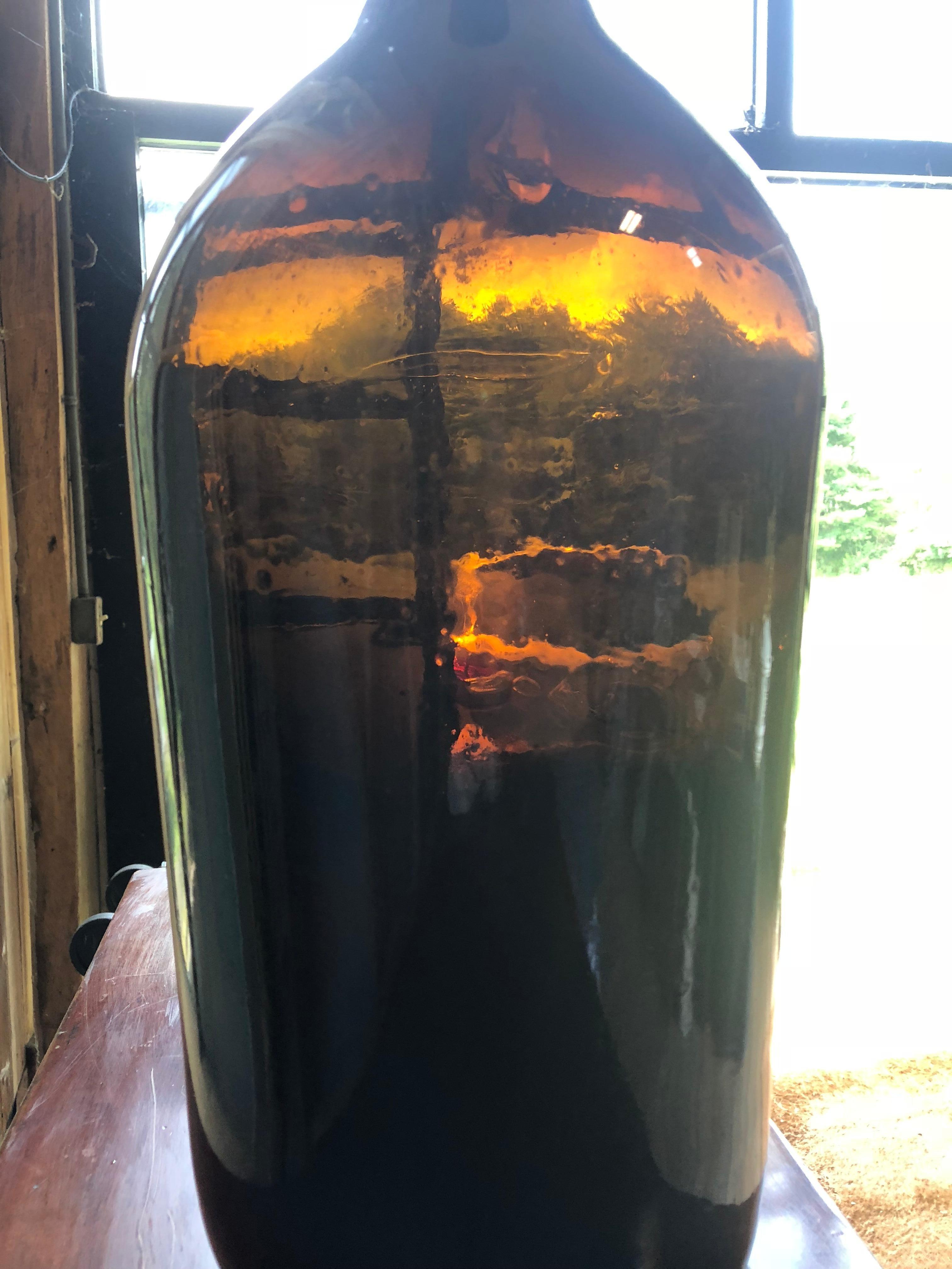 A large amber glass hand blown wine bottle, circa 1850.