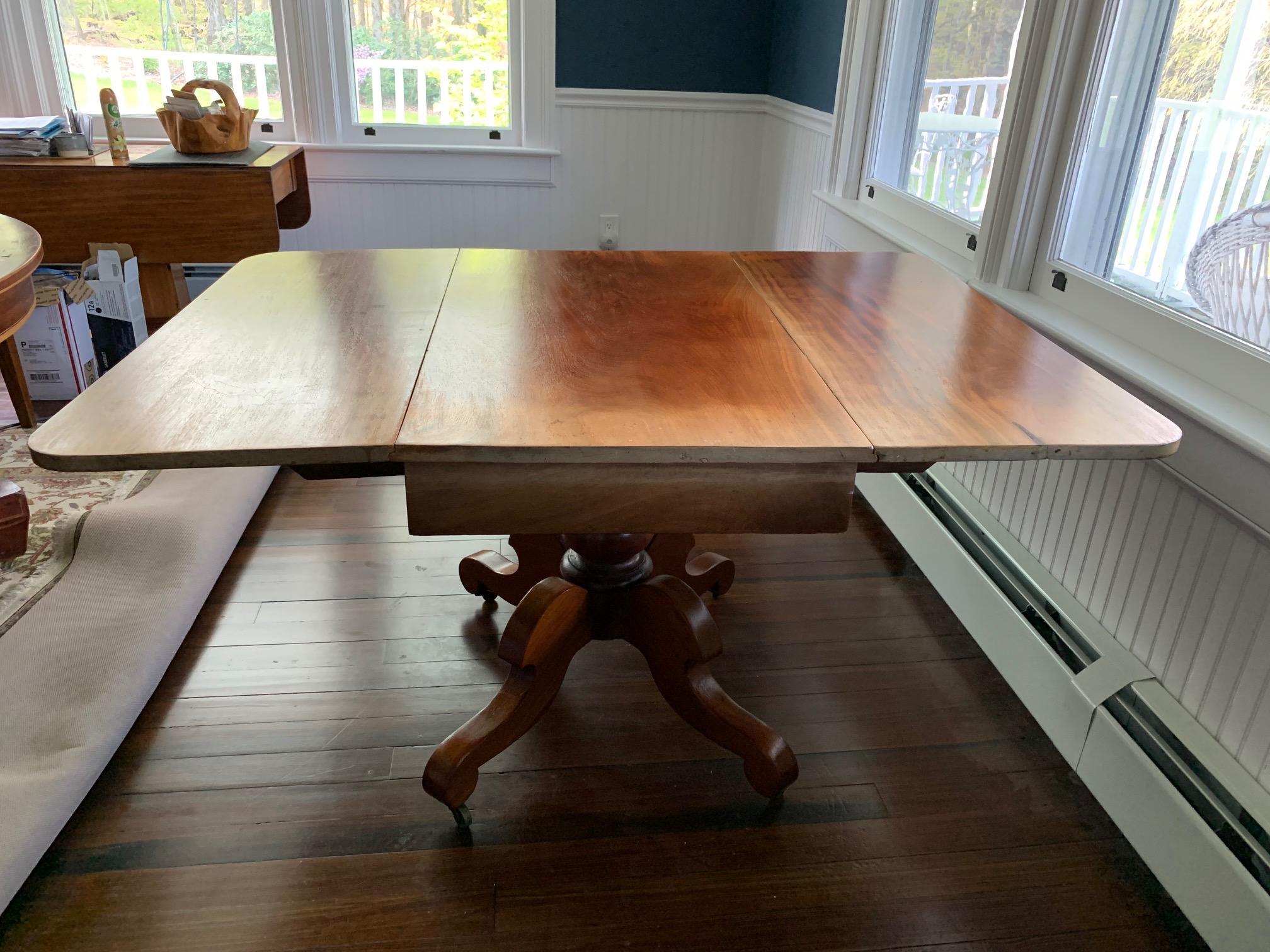 Large American drop leaf pedestal breakfast table, late 19th c.
Beautiful drop leaf table with central pedestal of four scrolling legs on casters. Probably an American maple. Considerable fading on one side of table. Good stable condition otherwise.