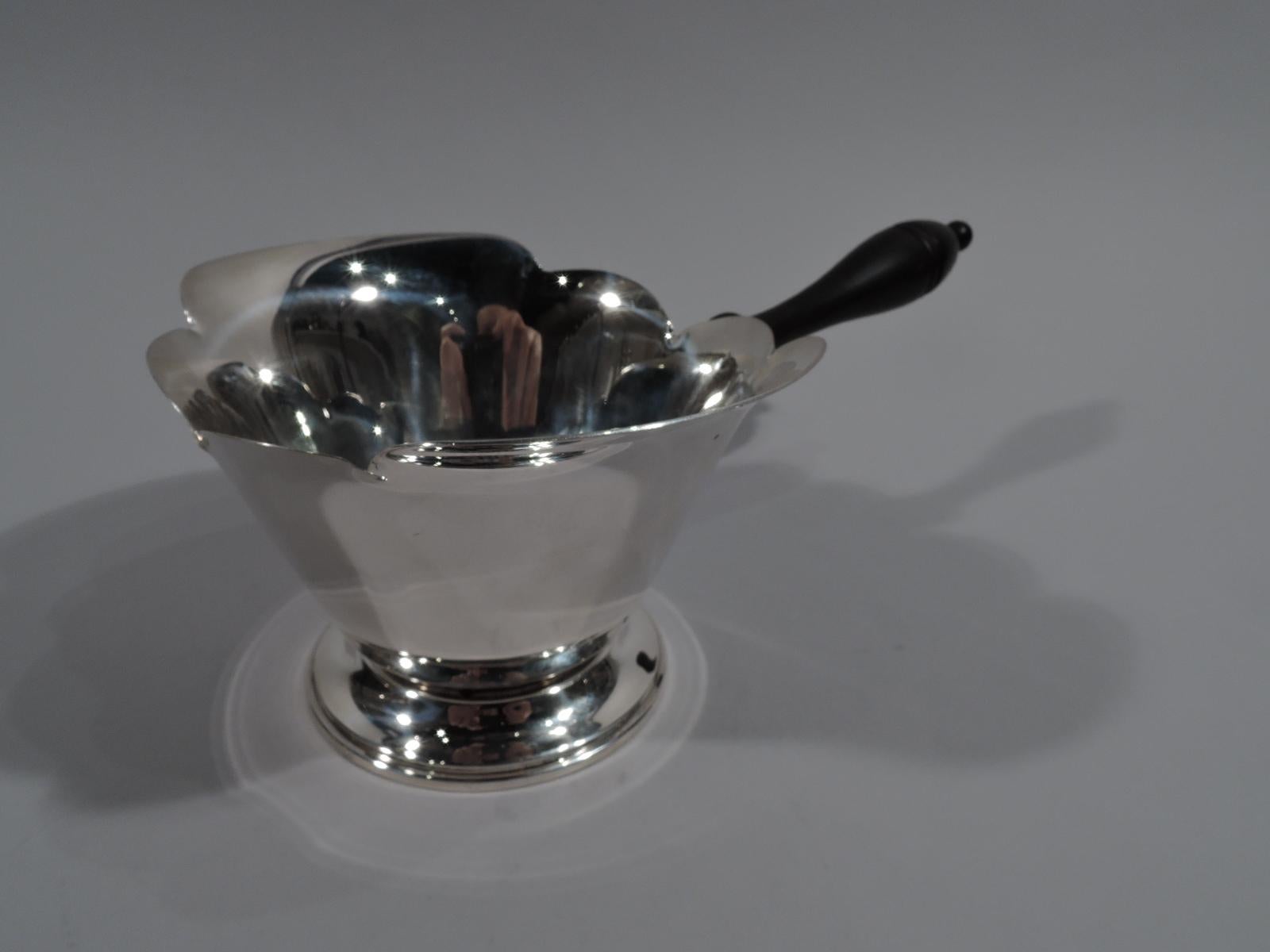 Large American Modern sterling silver pipkin. Conical bowl with scalloped rim and spread foot. Stained-wood baluster handle. Fully marked including maker’s stamp comprising letter A in triangle, and no. 403. 

Overall dimensions: H 3 1/2 x W 10 x