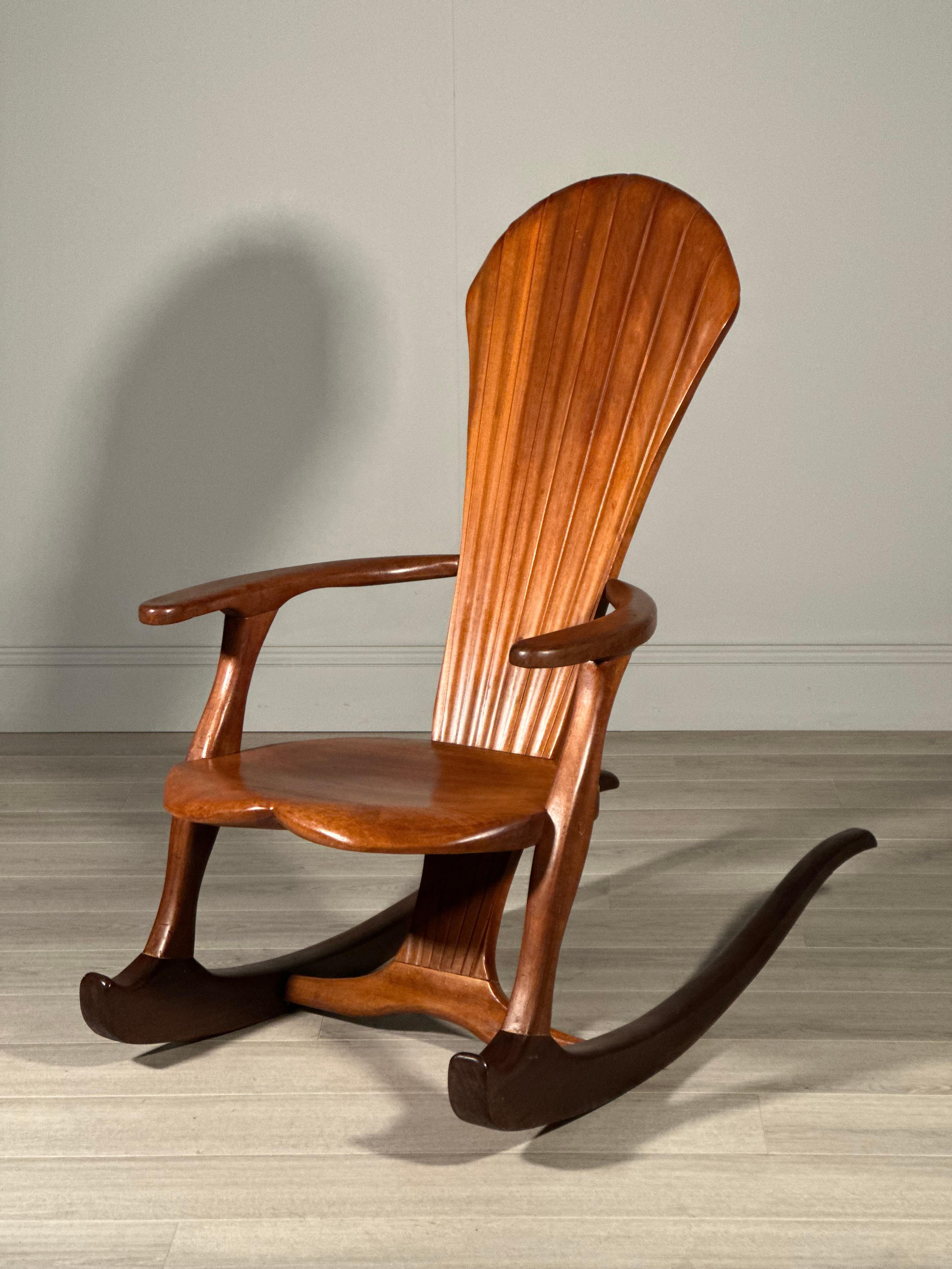A large American rocking chair dating to the 1950’s. The rocker is made from solid cherry wood, large in size and has a superb style to it with a high shell back, curved arm rest, love heart shape seat and long tailing rockers. In fantastic original