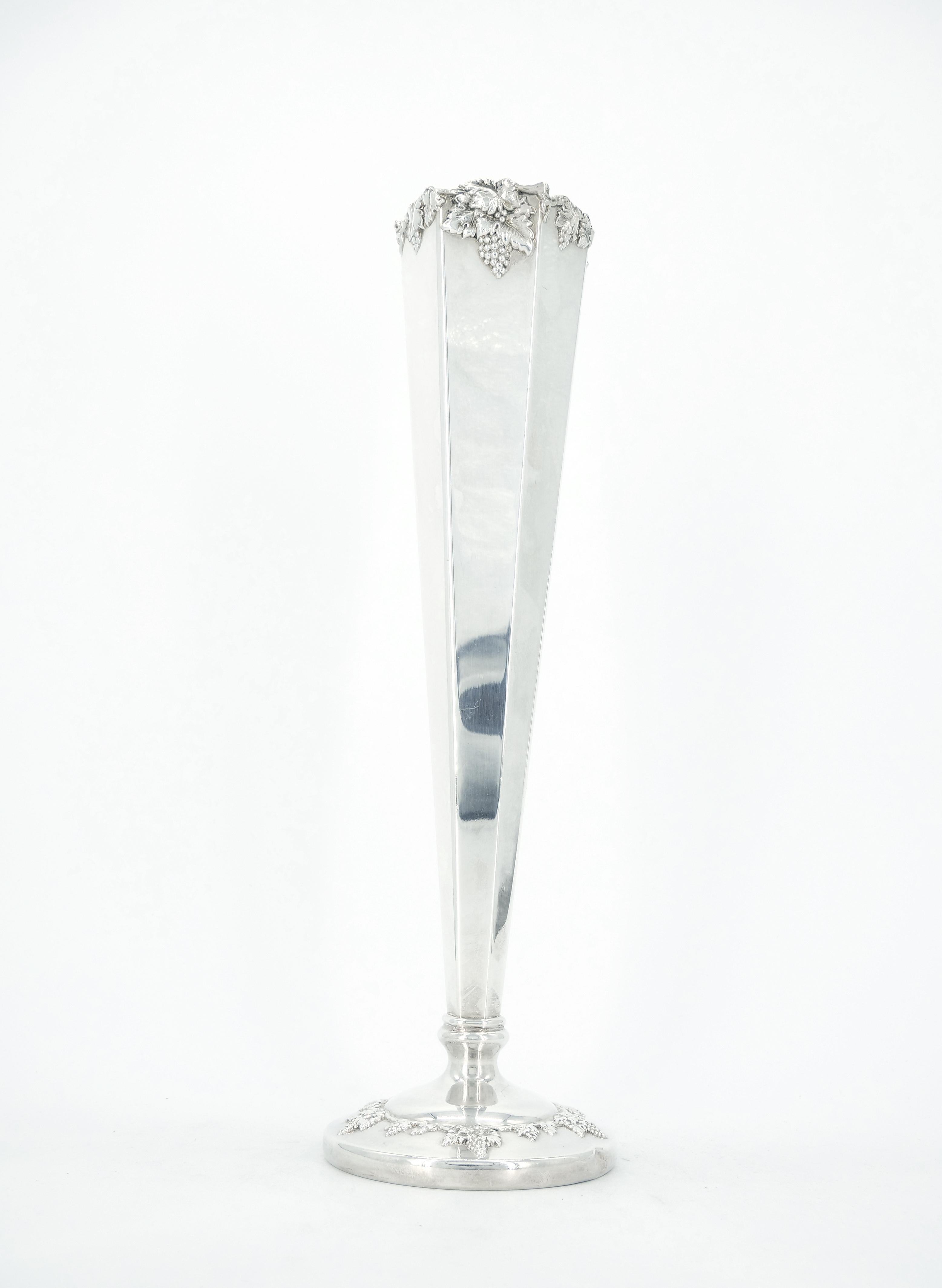 Large hexagonal tapered silverplate flower vase by Lawrence B. Smith Company of Boston, Massachusetts, with fine repeating grapevine motif decorating the rim and foot.  Founded in 1887, the firm operated into the 1950s.  5 inches across and 16