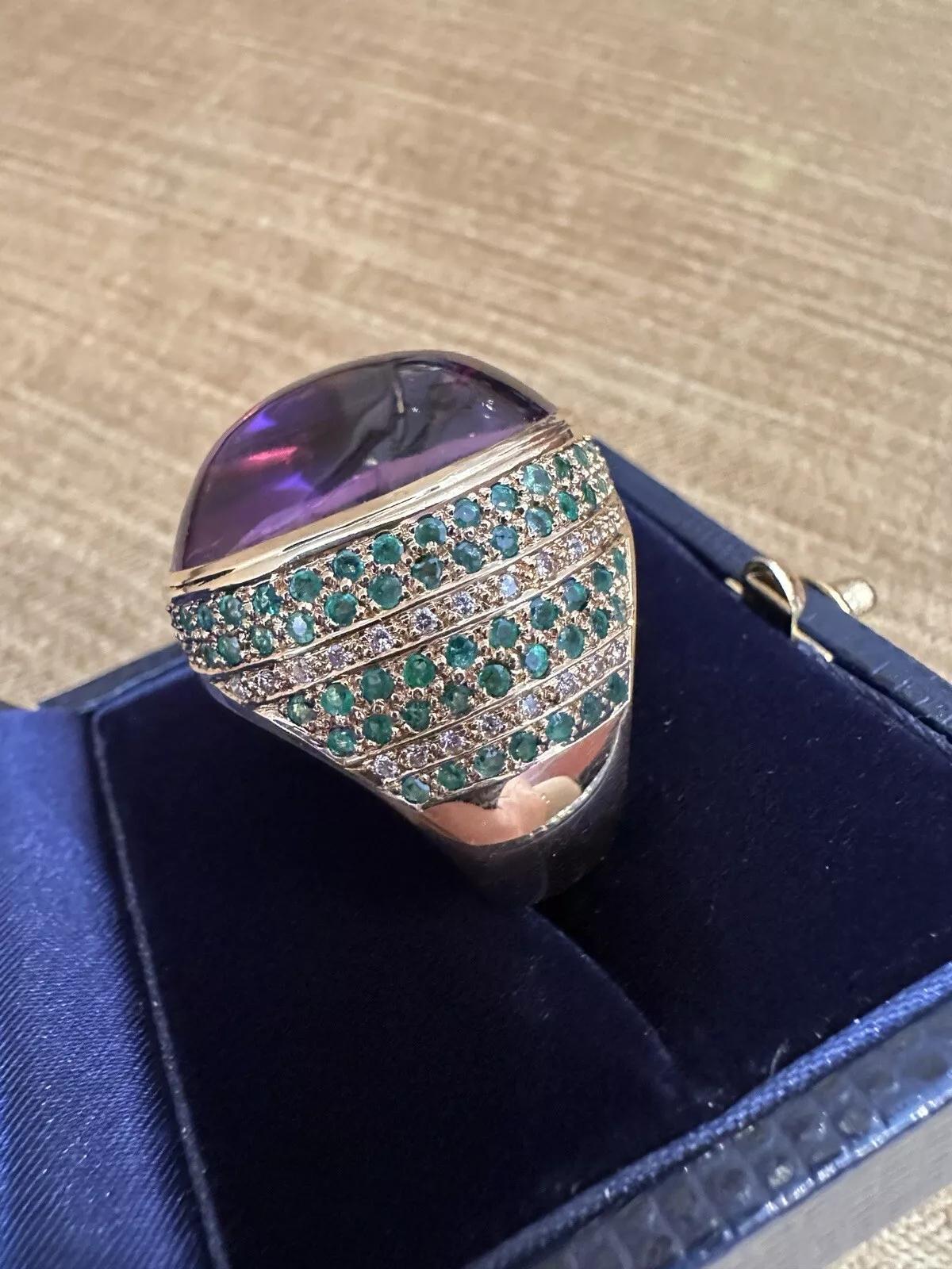 Großer Amethyst Cabochon Ring mit Diamanten in 18k Gelbgold 

Large Amethyst Dome Ring verfügt über eine 33,42 Karat natürlichen ovalen Cabochon Amethyst in einem 18k Gelbgold Einstellung mit grünen Edelsteinen und Diamanten pave entlang der Seiten