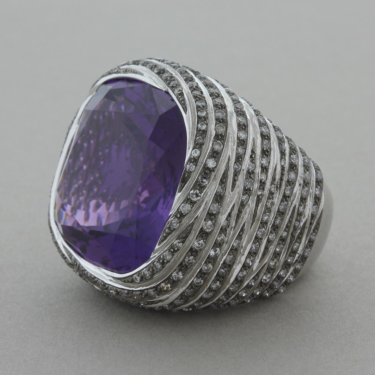 This ring features a majestic 25.32 carat cushion cut amethyst with a deep royal purple color. It is surrounded by 2.17 carats of round cut diamonds set in an 18K white gold. A big look for someone looking for a statement piece.  

Ring Size 6.5