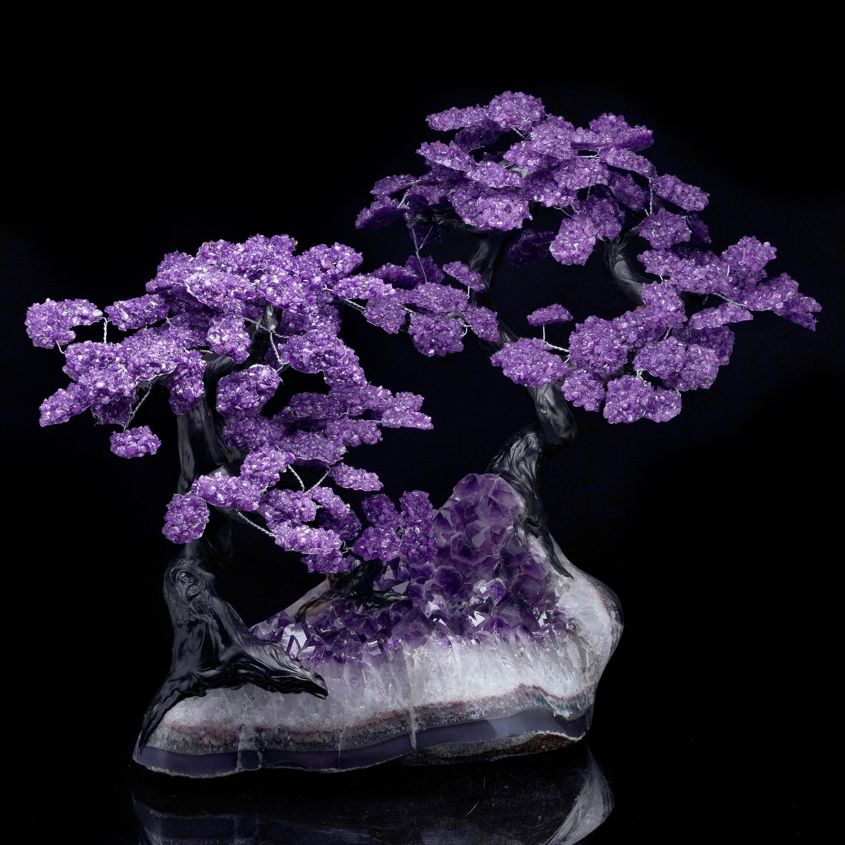 Add natural elegance to your space with this stunning handcrafted Amethyst Tree. Featuring vibrant purple natural amethyst crystal clusters, this decorative piece is rooted in a genuine amethyst geode base that showcases sparkling crystal points and