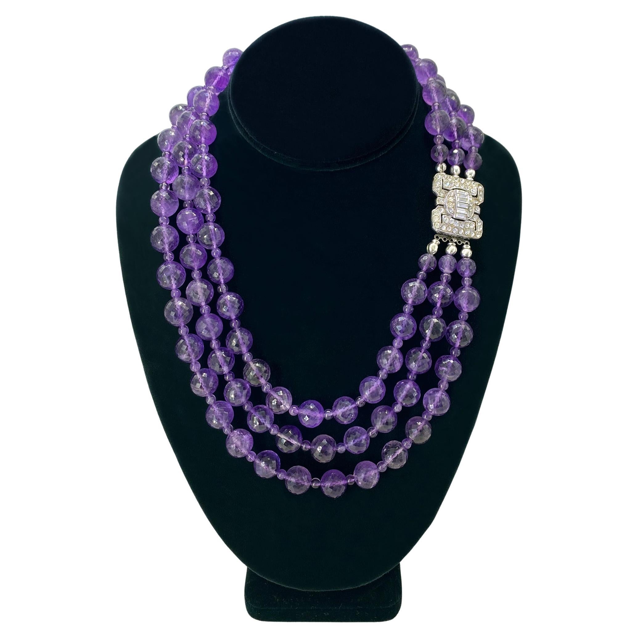 This is a triple strand amethyst necklace with an vintage Art Deco style clasp. We created this necklace with 11-12mm large faceted amethyst beads and 4mm smooth beads as spacer plus sterling silver findings. This necklace is high-lighted with a