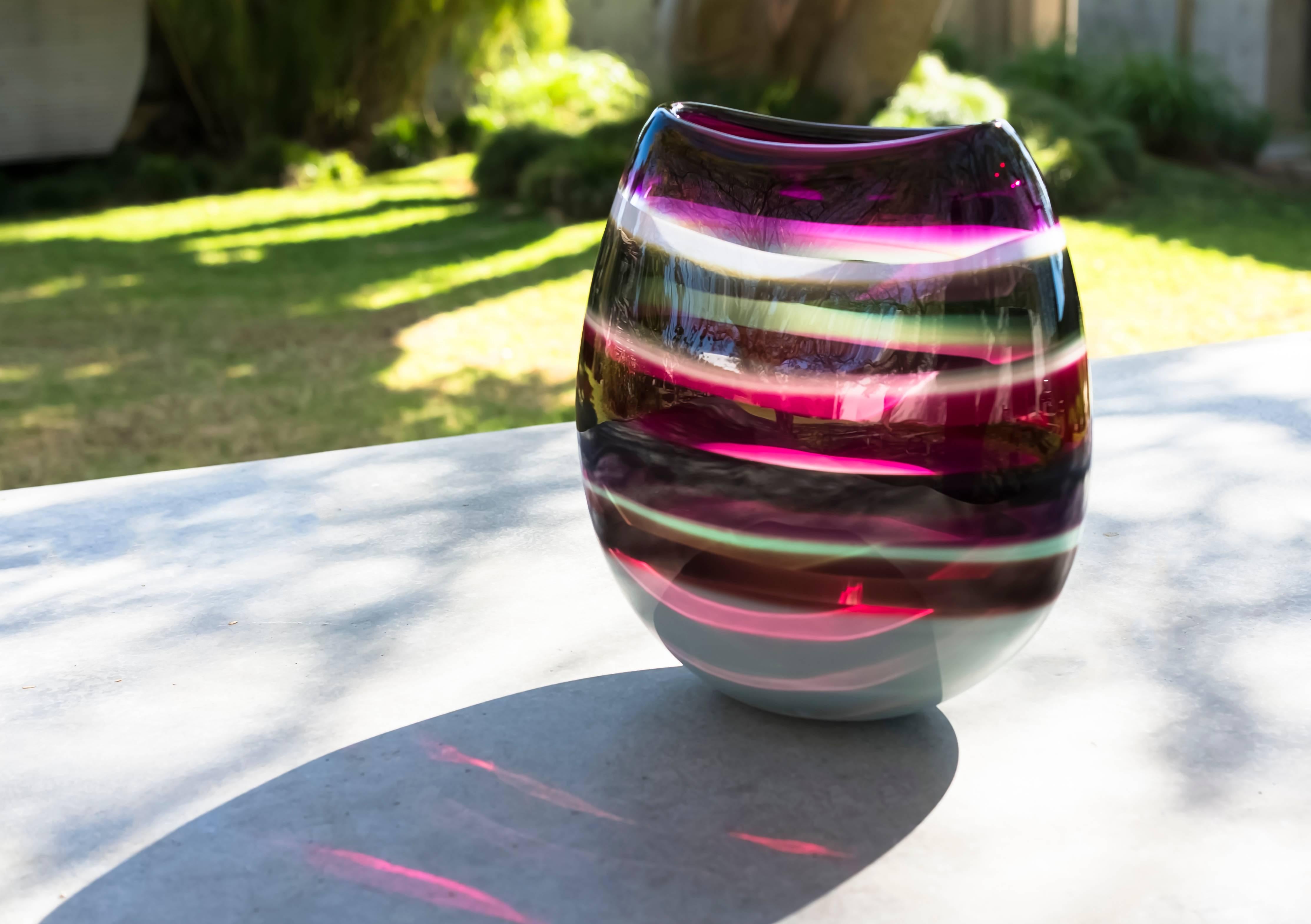 This hand blown vase draws inspiration from the rich hues and undulating topography of Southern California. Alternating layers of opaque and transparent colors are applied to clear glass. Overlaps create opportunities for new colors to be formed,