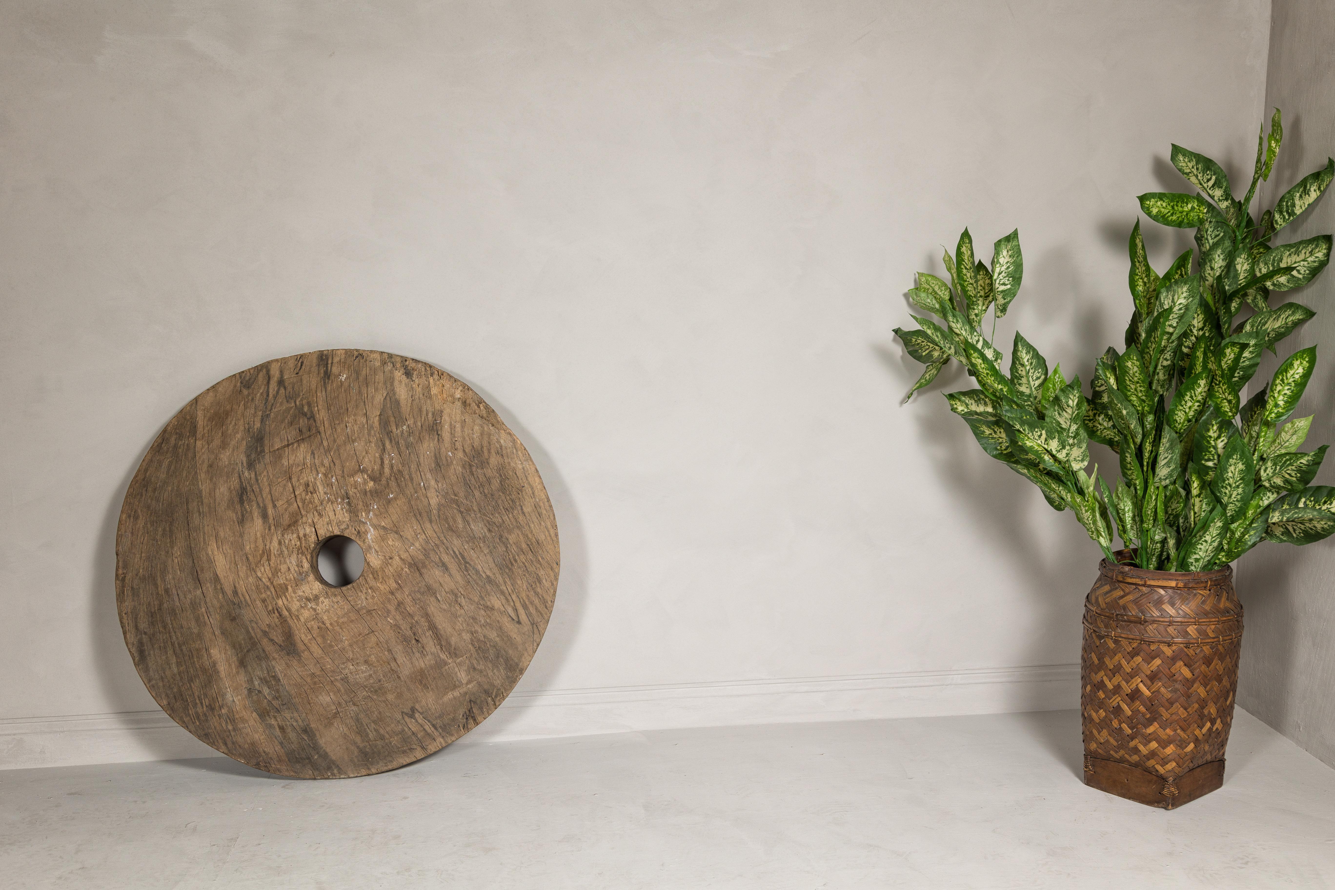 Dieses große, antike Wagenrad aus Holz strahlt einen sehr rustikalen Charakter aus und besticht durch seine authentische Patina und sein altes Aussehen. Das Rad mit seiner robusten Bauweise und den sichtbaren Altersspuren erzählt von langen Reisen