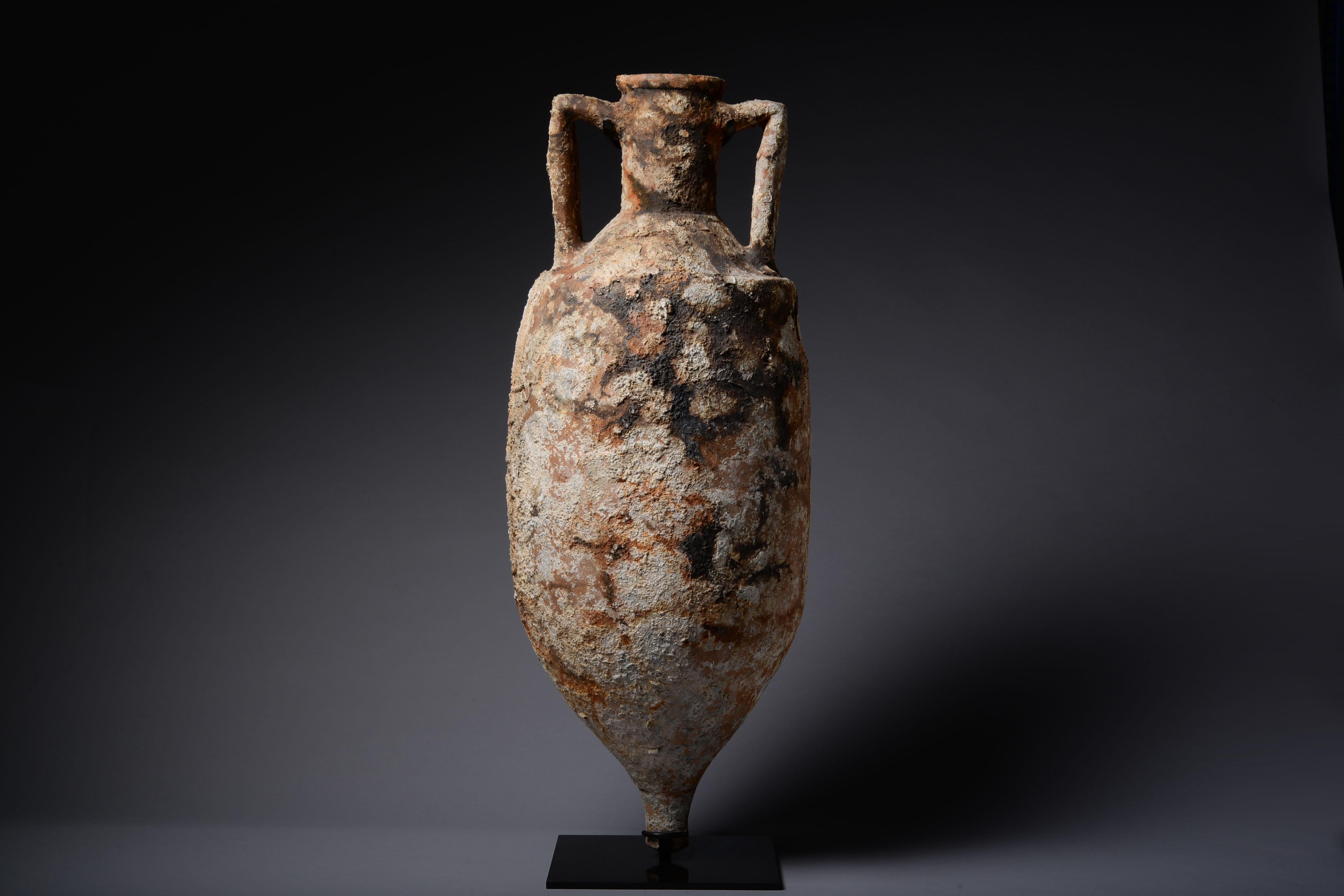 A large and beautifully encrusted ancient Roman Amphora, sea salvaged and dating to the 1st-2nd century AD.

Salvaged from the depths of the Mediterranean, this large vessel was lost in some ancient shipwreck. Once filled with the produce of the