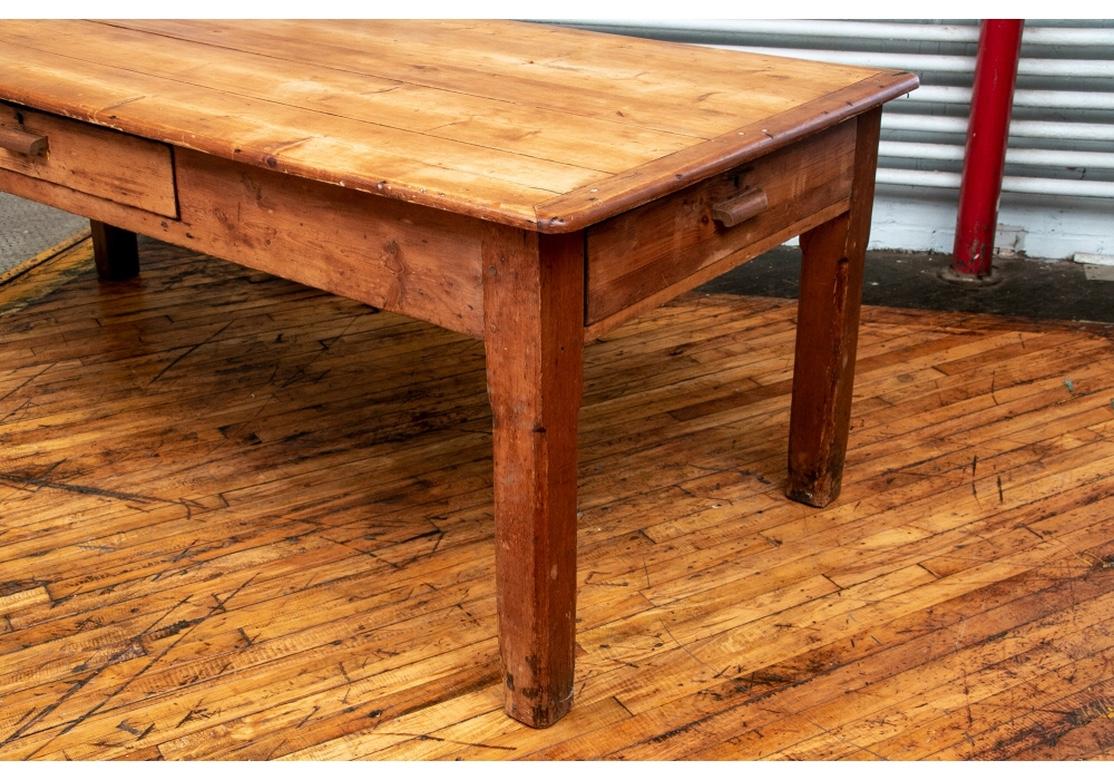 A large and authentic farm/work table with generous proportion, good stability and excellent aging. Plank constructed top with bread board ends the apron with one-drawer on each long side (one-drawer is divided and the other is missing the bottom