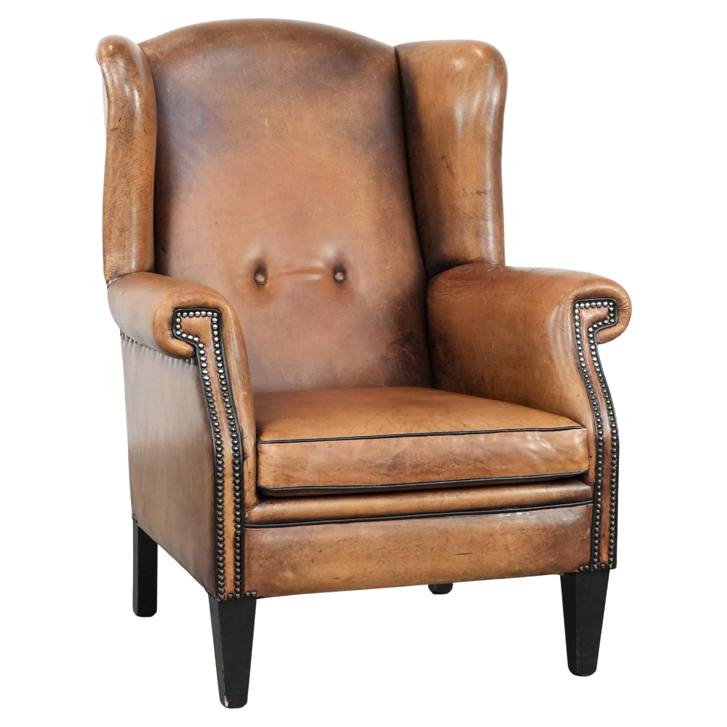Large and comfortable sheepskin leather wingback chair with black piping For Sale