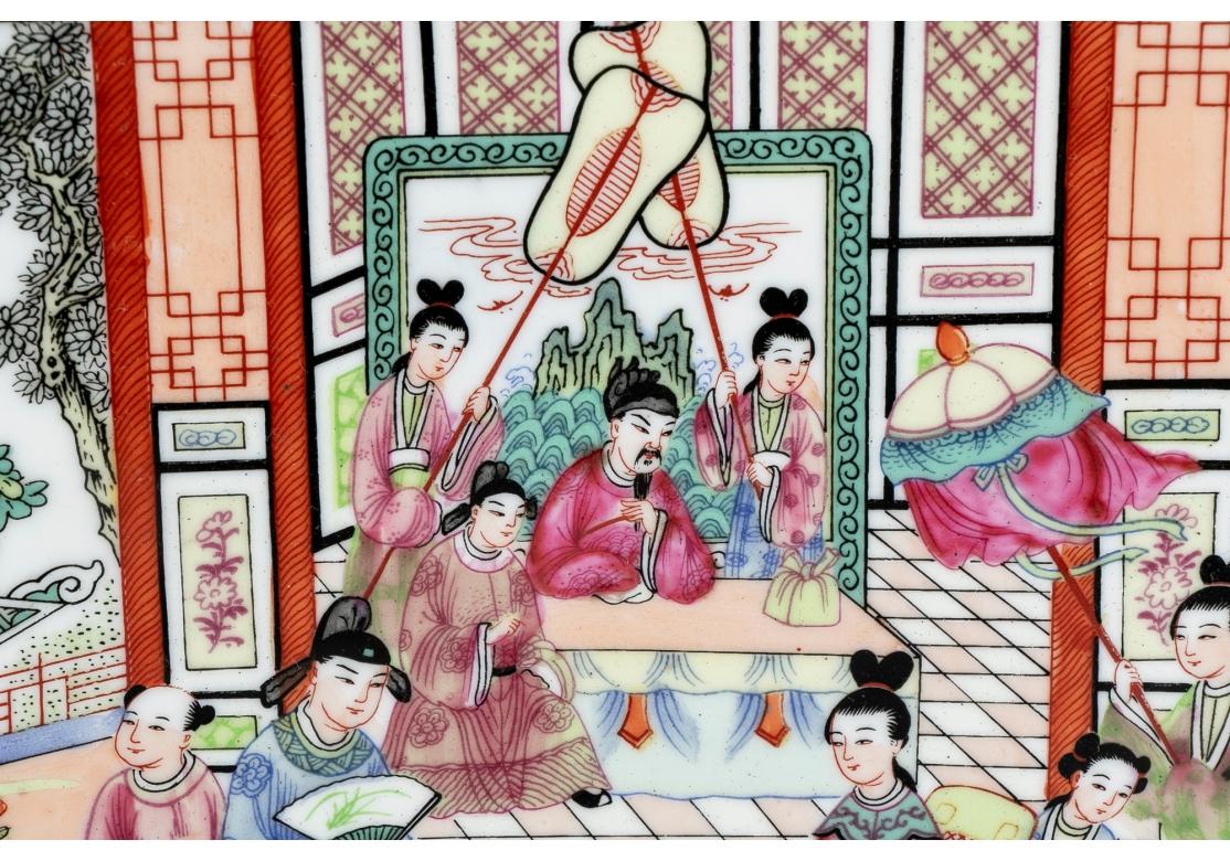 A massive Chinese porcelain charger plate with a central palatial scene with a gentleman under the structure and the attendants with fans, a woman in a wheel chair to the right and the attendants and other figures in acknowledgment.
The charger