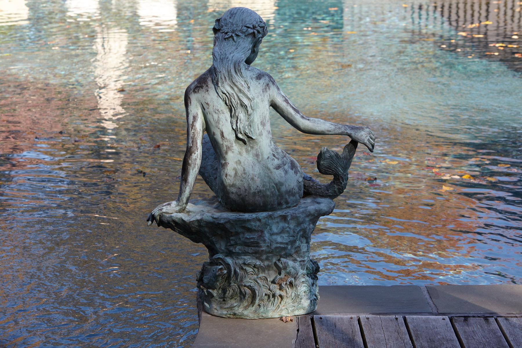 A beautifully detailed bronze water garden/fountain statue of a mermaid sitting on a stone, circa 1940s. The statue has a wonderful, lovely green patina. The statue is piped.
    