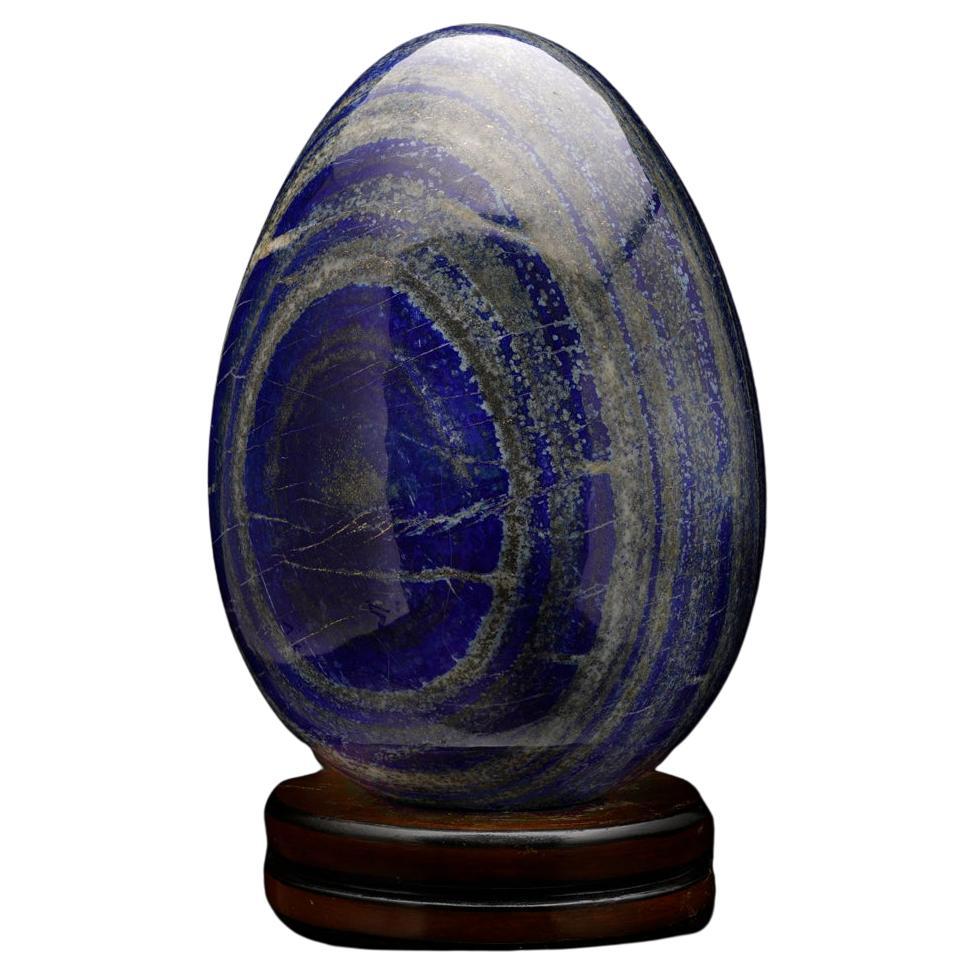 This magnificent 47-pound lapis lazuli egg is carved out of top quality cobalt blue lapis. Hand carved from Afghanistan  it offers incredible uniquely concentric banding of contrastingly white calcite and shimmering golden pyrite inclusions for a