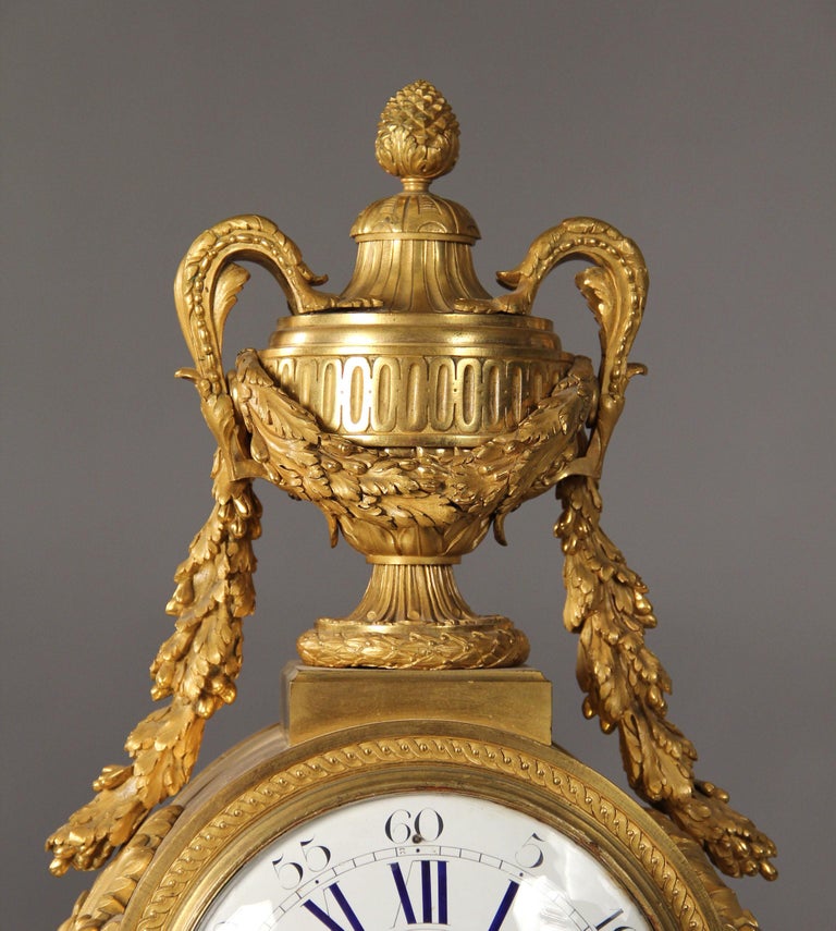 A large and fine quality late 19th century gilt bronze mantle clock by Guibal Paris

A large urn with handles and wrapped in laurel leaves above the round clock face, the curved sides sitting on a detailed rectangular bronze base standing on four
