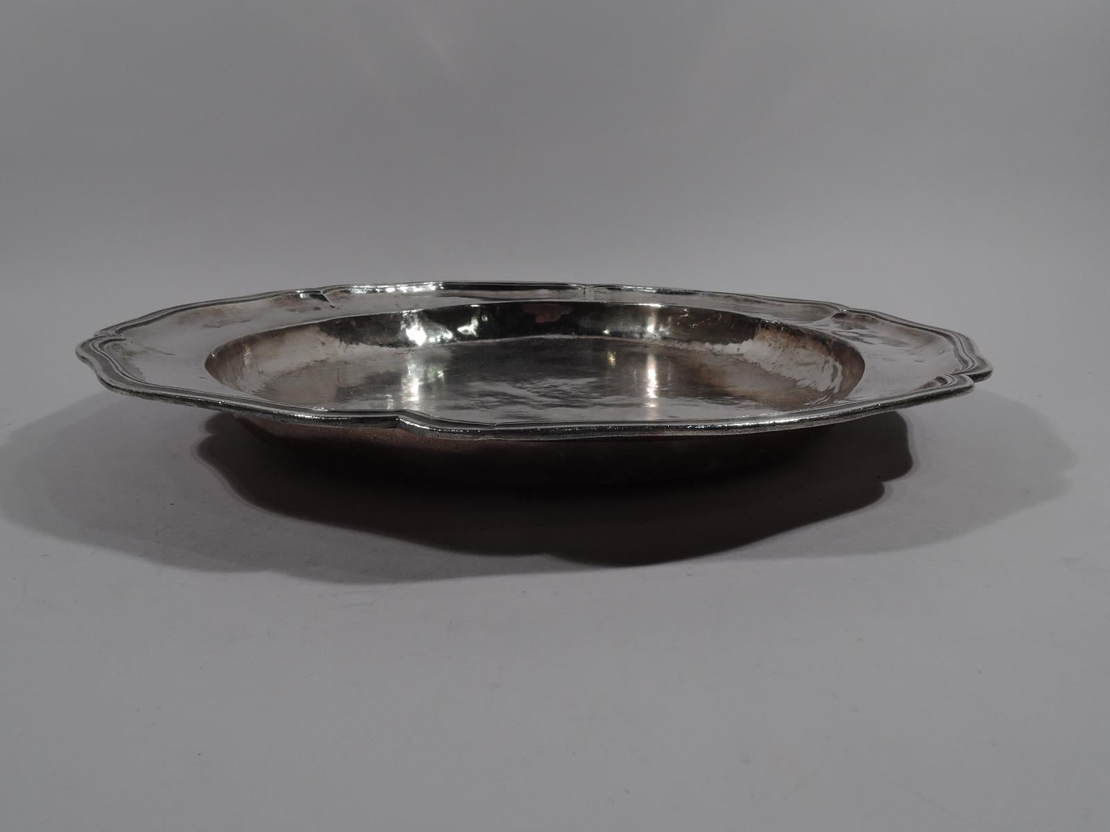 Large and heavy South American silver charger, late 18th-early 19th century. Round and deep well, wide shoulder, and molded, lobed, and scrolled rim. Visible handwork and tooling with attractive irregularities. Mass and heft. Marked. Weight: 55 troy