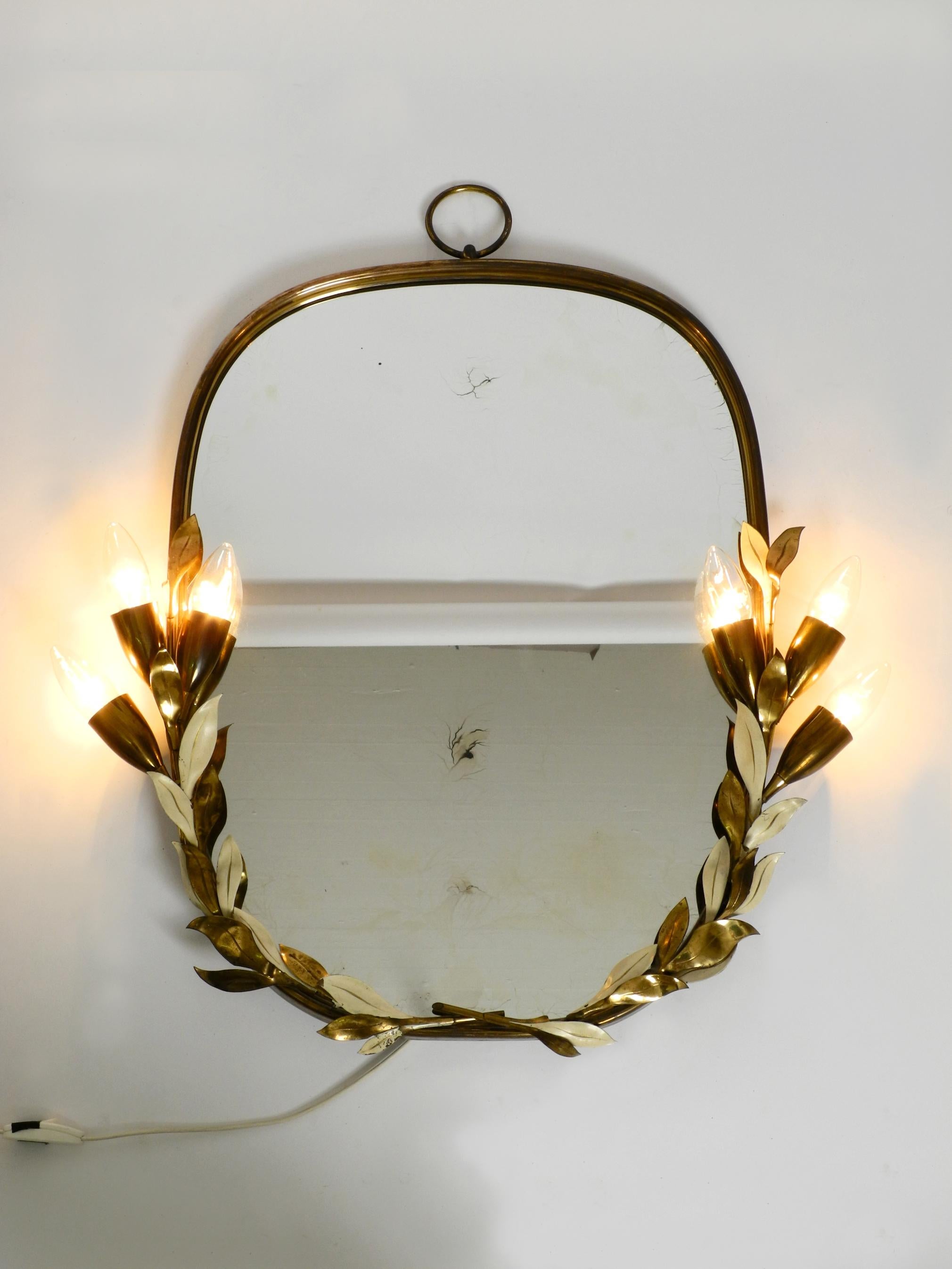 Extraordinaire grand et lourd miroir lumineux floral en laiton.
Fabriqué par Vereinigte Werkstätten. Fabriqué en Allemagne.
Version très rare avec un motif floral, avec de nombreux détails.
Le cadre complet est en laiton pur, certaines feuilles