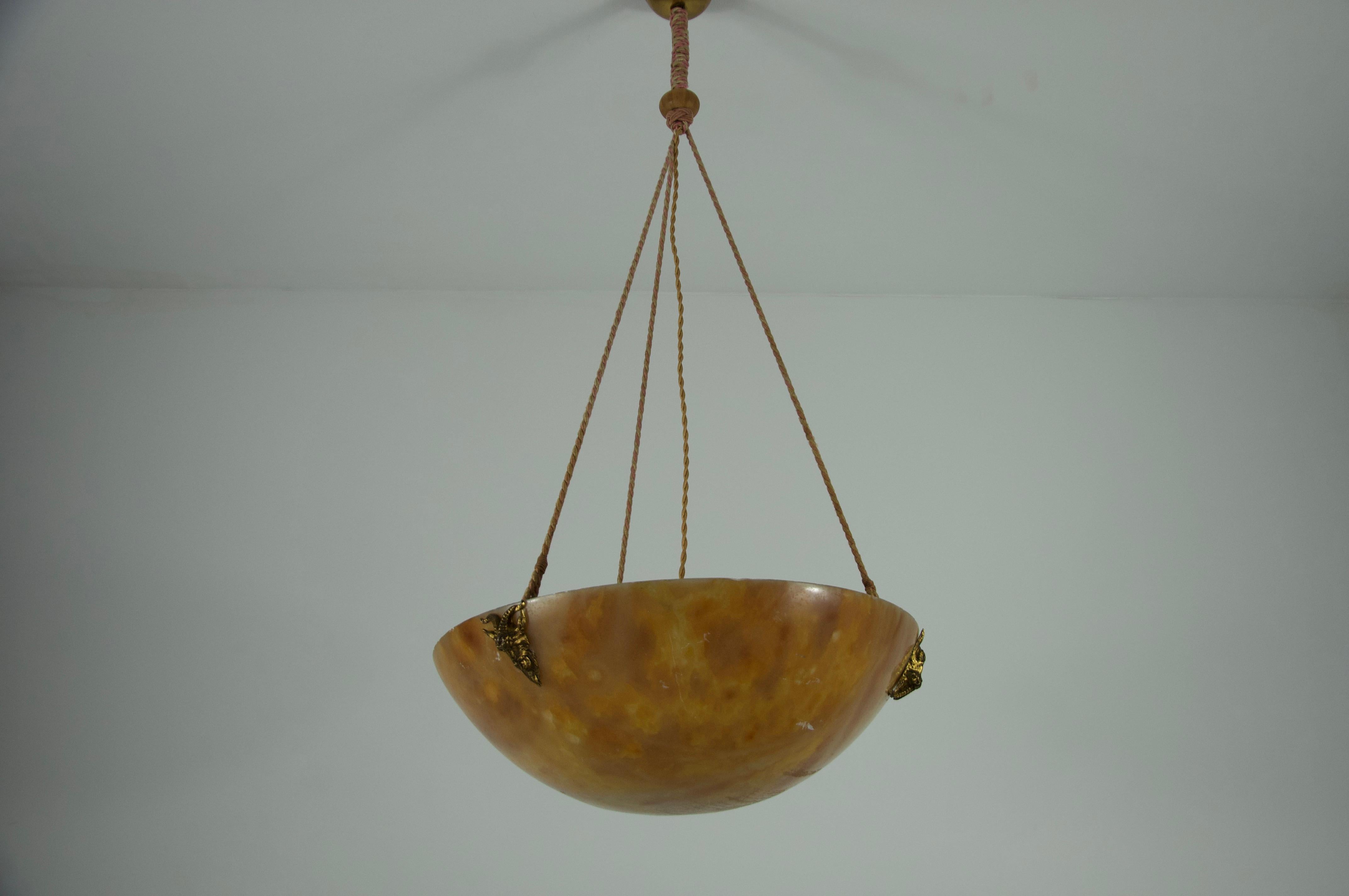 This large and heavy hand-carved alabaster ceiling lamp was crafted in Germany during the 1930s and is a striking example of early 20th-century craftsmanship. The generously sized bowl is made from richly veined, warm-toned alabaster, creating a