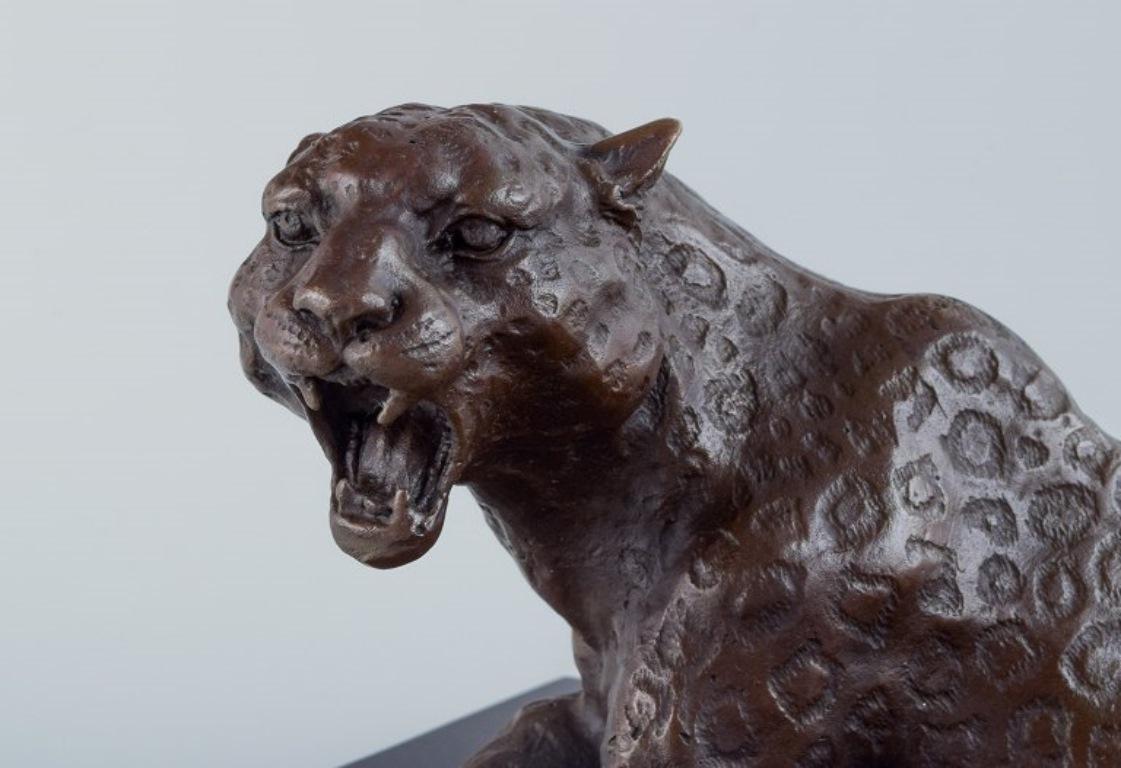 20th Century Large and heavy sculpture of a cheetah in patinated bronze on a marble base.  For Sale