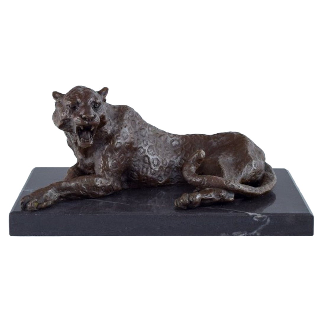 Large and heavy sculpture of a cheetah in patinated bronze on a marble base.