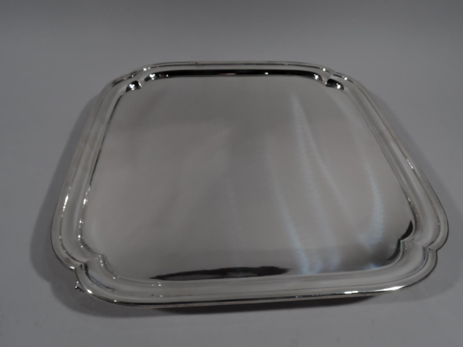 George VI sterling silver salver. Made by Edward Viner in Sheffield in 1946. Four curved sides with molded rim and lobed corners. Leaf-capped volute-scroll corner supports. A traditional postwar piece with good heft. Full marks as well as stamp for