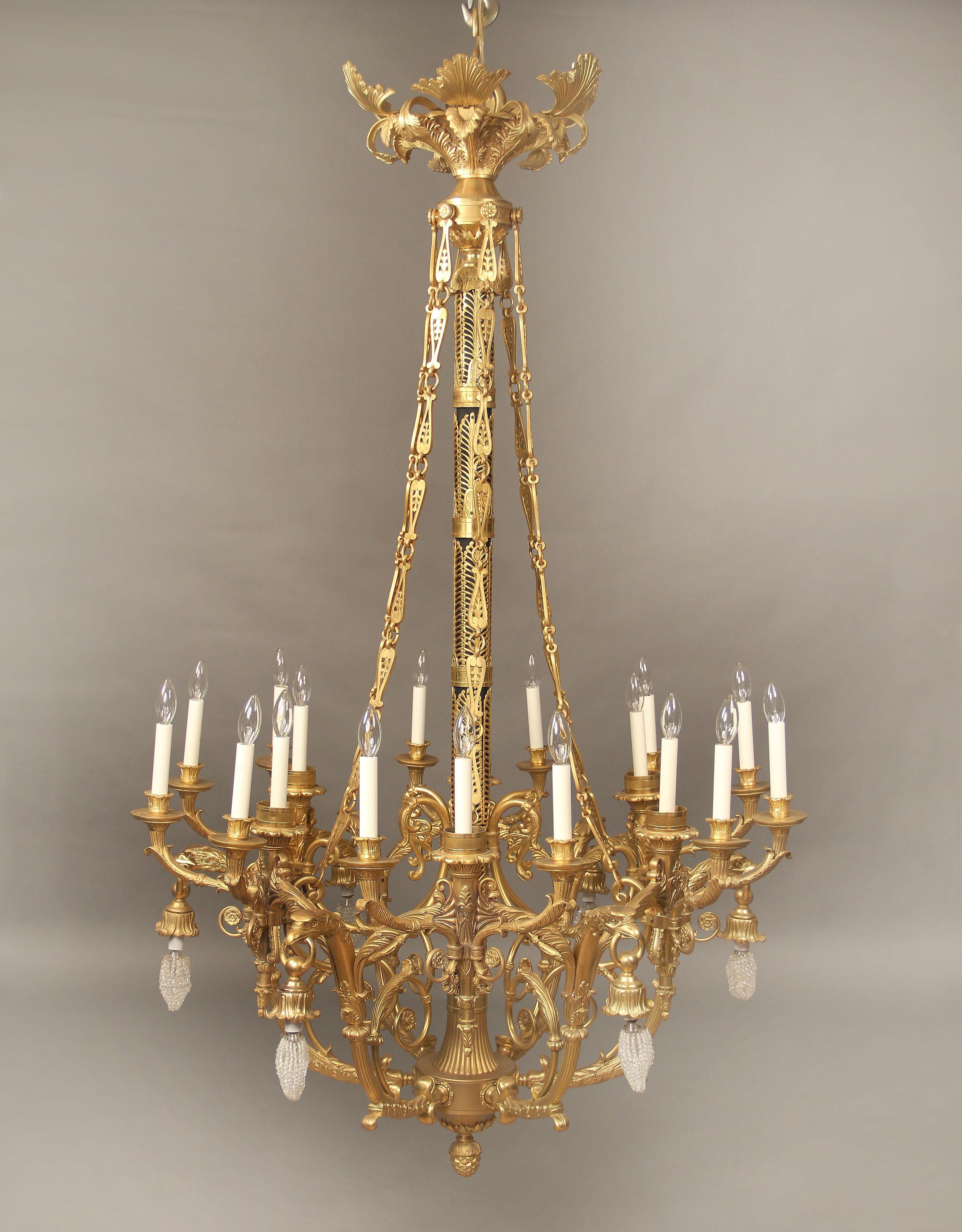 A large and important early 20th century gilt bronze twenty four light empire style chandelier.

The wonderful casted all bronze frame decorated with empire designs, with bronze chains from the crown to the body, the arms consisting of torches and