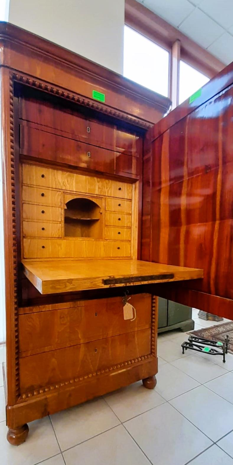 Grand et important secrétaire français.
Meuble impressionnant d'une excellente ébénisterie.
Extérieurement, le meuble ressemble à une armoire avec des tiroirs et une grande porte finement incrustée en noyer et amarante sur un fond clair de bois