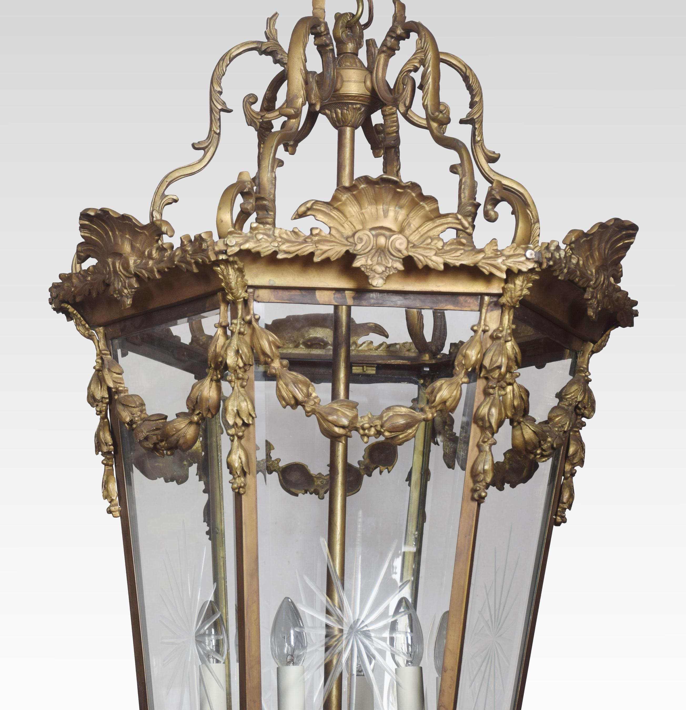 Large and imposing gilded cast brass six light lantern of hexagonal form the engraved glass panels enclosed in frame with leaf scroll crestings and floral swags. The central six lights have been rewired and tested.
Dimensions
Height 51