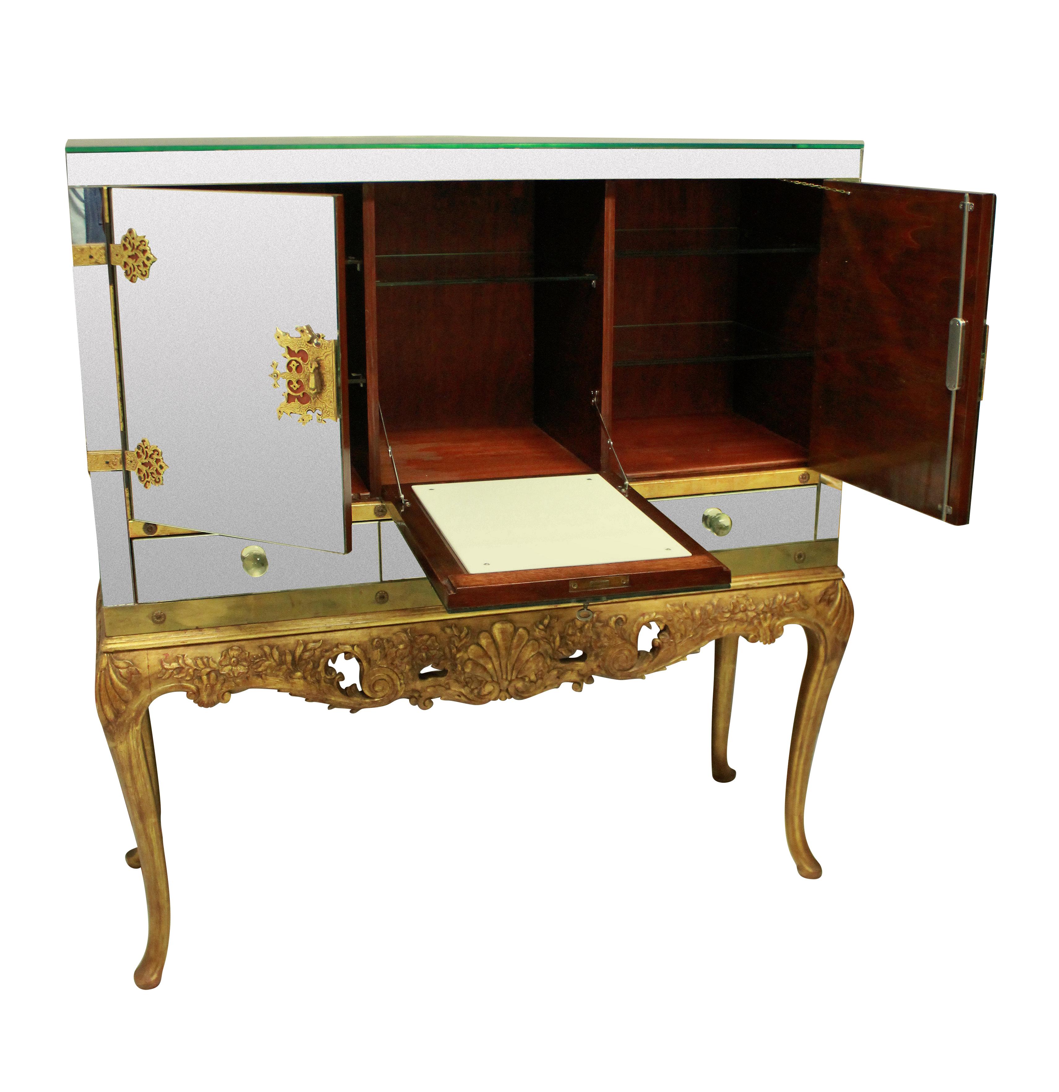 A large and impressive American bar cabinet in the chinoiserie taste. The upper section of good quality with mirror panels throughout resting upon a carved and gilded base. The intricate locks and hinges in gilt bronze with working locks and keys