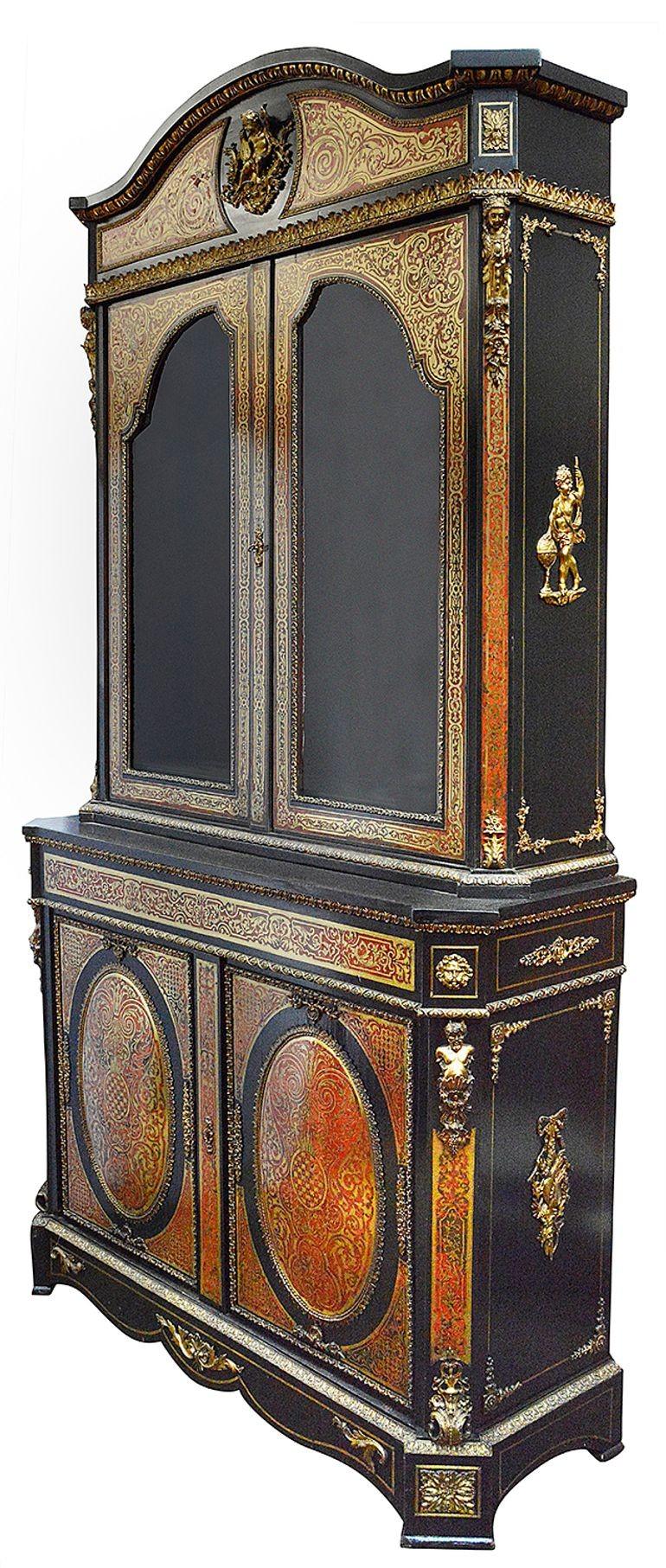 Questa splendida vetrina intarsiata Boulle francese del XIX secolo è un esempio di squisita maestria e opulenza. Realizzato in ricco mogano e impreziosito da intarsi in ottone e tartaruga, presenta un design sorprendente e ornato che cattura